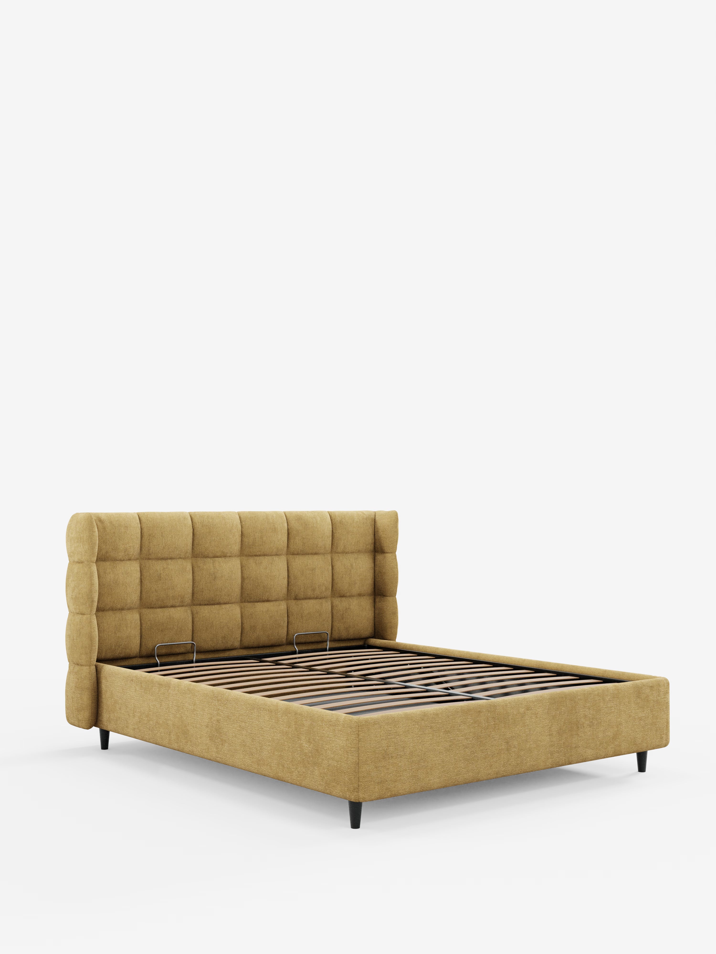 Il letto imbottito RAGNAR con vano contenitore e testiera capitonné avvolgente di Letti.Il negozio ne mette in risalto il design moderno grazie a un elegante tessuto giallo senape certificato Oeko-Tex®, una testiera imbottita con motivo a griglia, robuste doghe in legno per il sostegno del materasso e corte gambe nere, il tutto presentato su uno sfondo bianco a tinta unita.