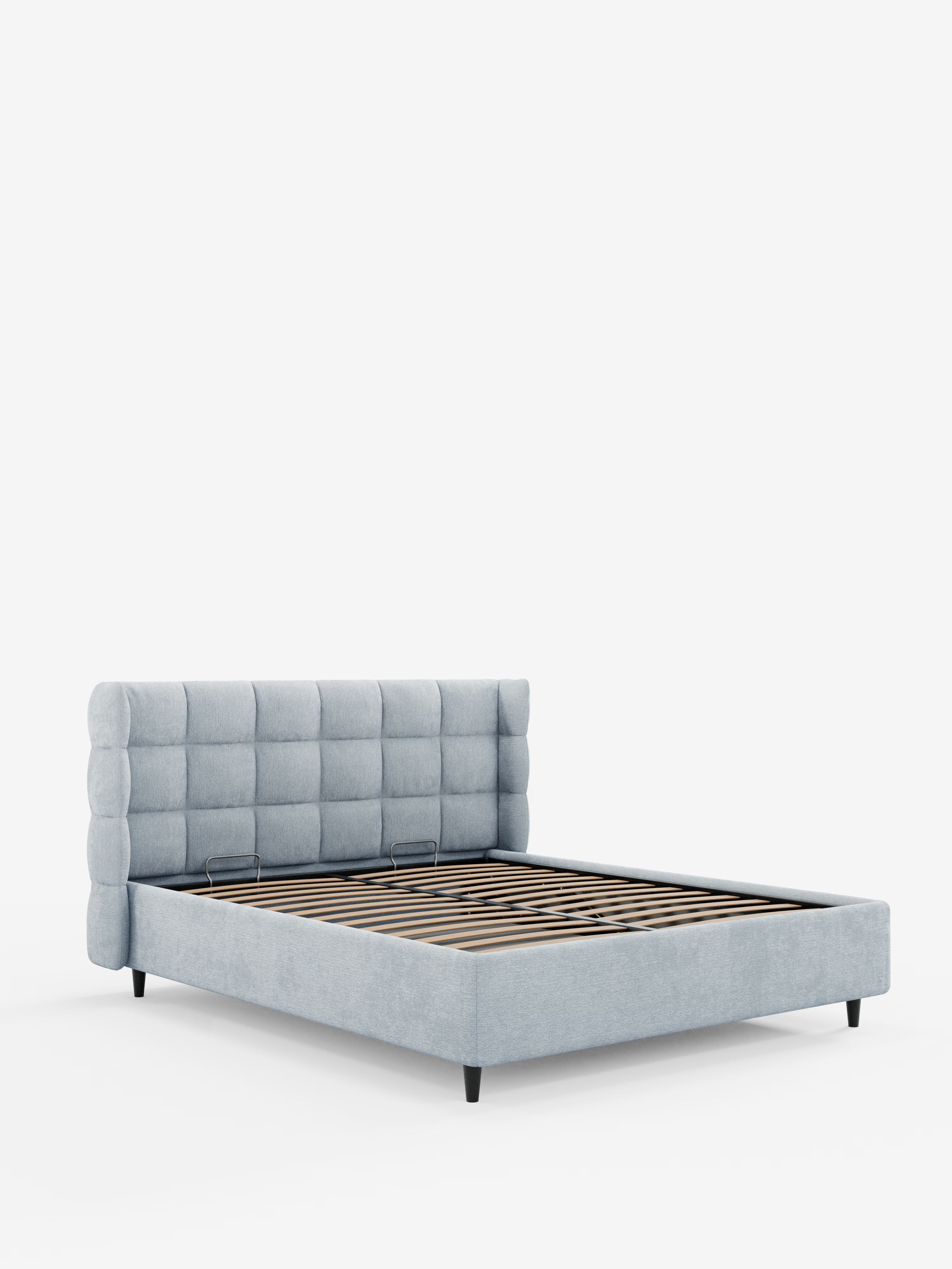 Il letto imbottito con contenitore RAGNAR di Letti.store è presentato in un tessuto azzurro, certificato Oeko-Tex®. È caratterizzato da una testiera alta e avvolgente, con rivestimento capitonné e un elegante motivo a griglia, e da fianchi bassi e imbottiti. Il letto è dotato di doghe in legno per il sostegno del materasso e poggia su corte gambe nere, che risaltano sullo sfondo bianco a tinta unita.