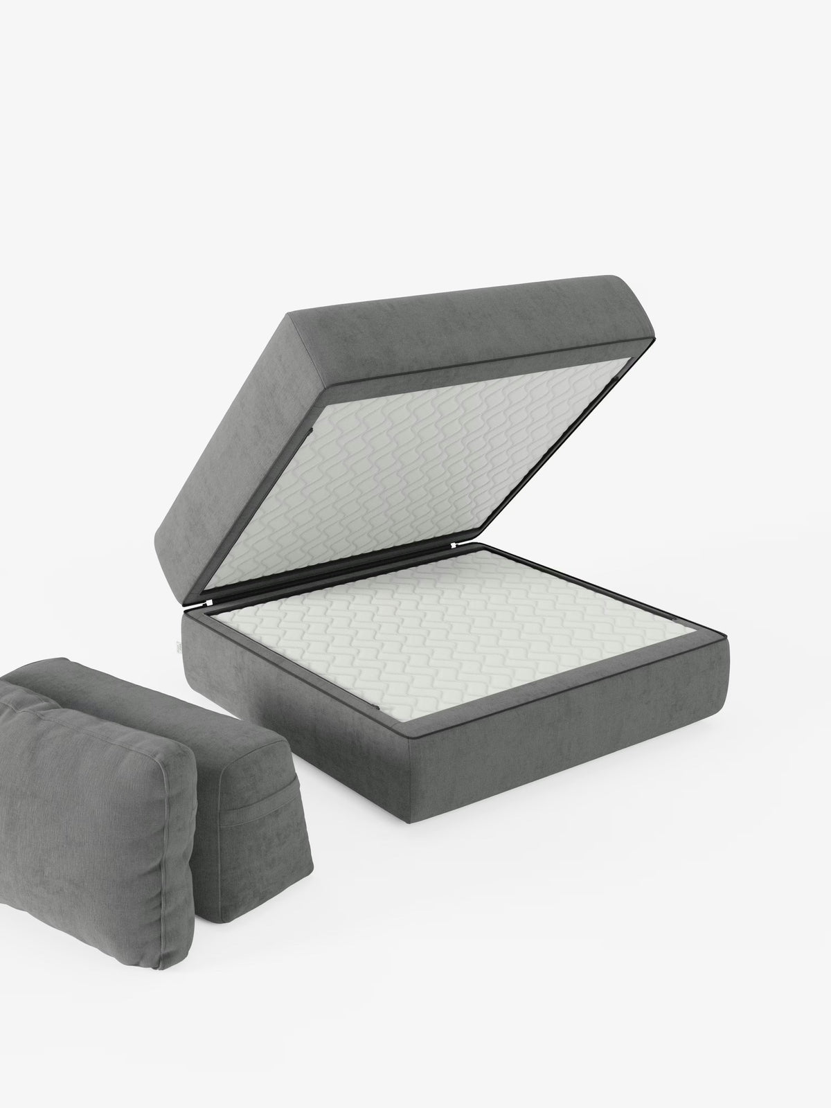 Una “Rift poltrona letto” grigia di Divani.Store, dotata di un materasso in memory foam alto 24 cm e di uno schienale regolabile, è raffigurata con la base imbottita e sollevata, che rivela l’ampio vano contenitore al suo interno. Due cuscini grigi abbinati, ispirati allo stesso design, sono posizionati a terra nelle vicinanze, su uno sfondo bianco a tinta unita.