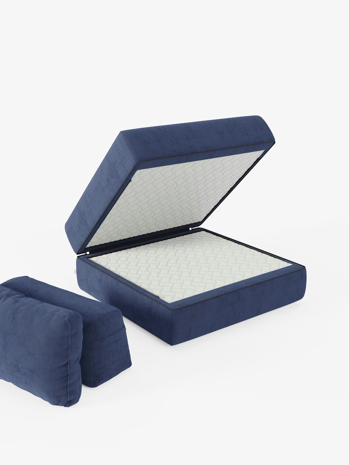 Una poltrona letto Rift in velluto blu di Divani.Store, dotata di coperchio incernierato, è aperta e mostra al suo interno un materasso in memory foam bianco trapuntato da 24 cm: un perfetto esempio di poltrona trasformabile. Due cuscini blu rimovibili sono appoggiati accanto ad essa su uno sfondo bianco a tinta unita. La scena è ben illuminata e minimalista, mettendo in risalto lo schienale mobile e il tessuto T31 facile da pulire.