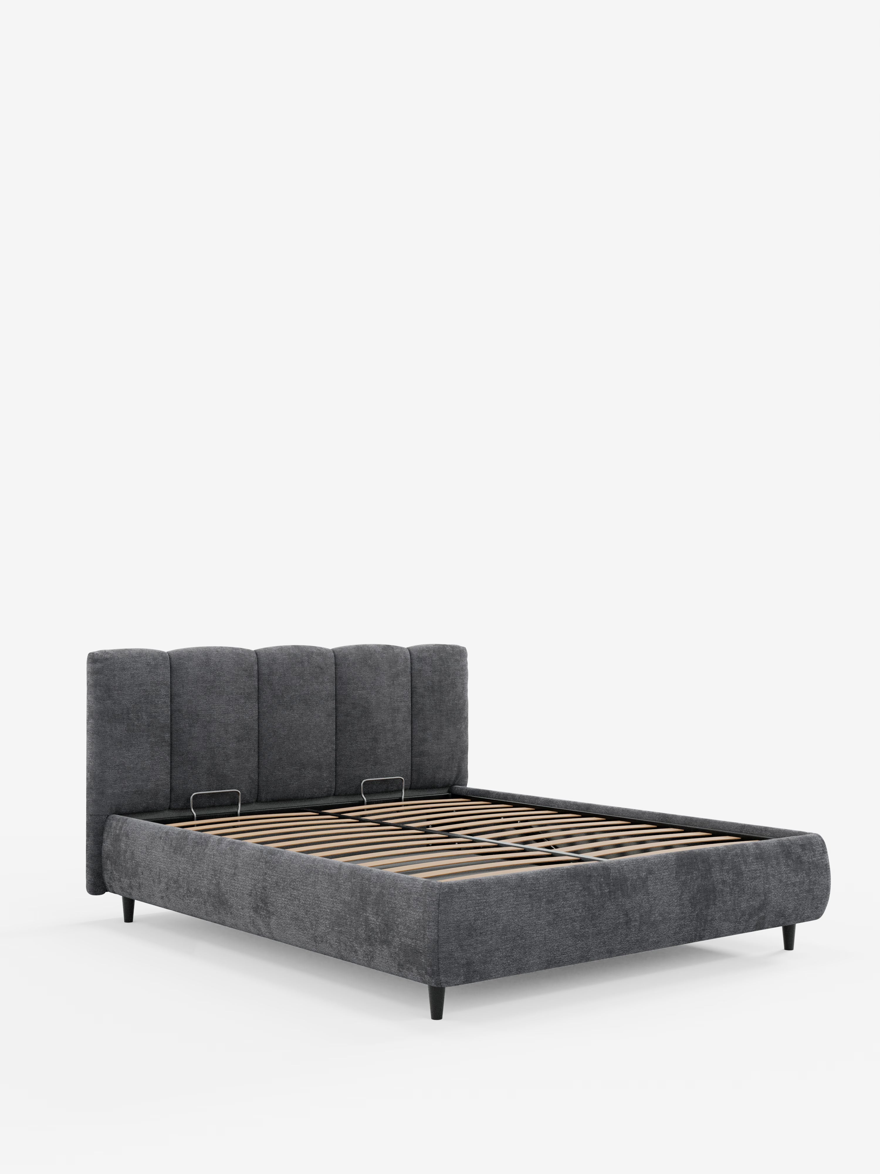 Il letto imbottito ARKAM di Letti.store presenta un design shabby chic con testiera imbottita grigia e cuciture verticali, sponde laterali basse, gambe corte nere e doghe in legno a vista per il sostegno del materasso. Realizzato in tessuto certificato Oeko-Tex® e dotato di un pratico vano contenitore, questo letto è presentato su uno sfondo bianco a tinta unita per un look contemporaneo ma accogliente.