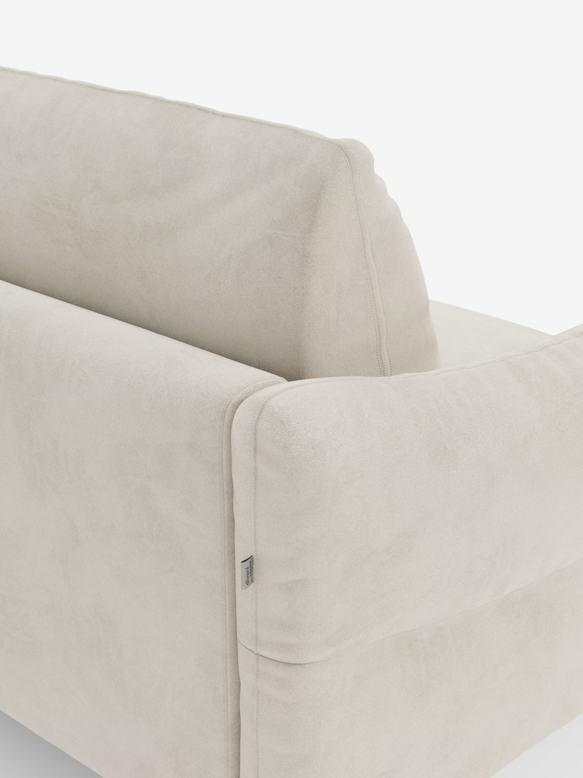 Primo piano dello schienale e del bracciolo del divano letto Dalia a 2, 3 e 4 posti di Divani.Store, rivestito in morbido tessuto vellutato T30 moderno, facile da pulire, in una tonalità di beige chiaro. Il tessuto morbido, simile alla pelle scamosciata, mette in risalto le cuciture a vista lungo i bordi, mentre sul lato è applicata una piccola etichetta in tessuto. Lo sfondo è bianco a tinta unita.