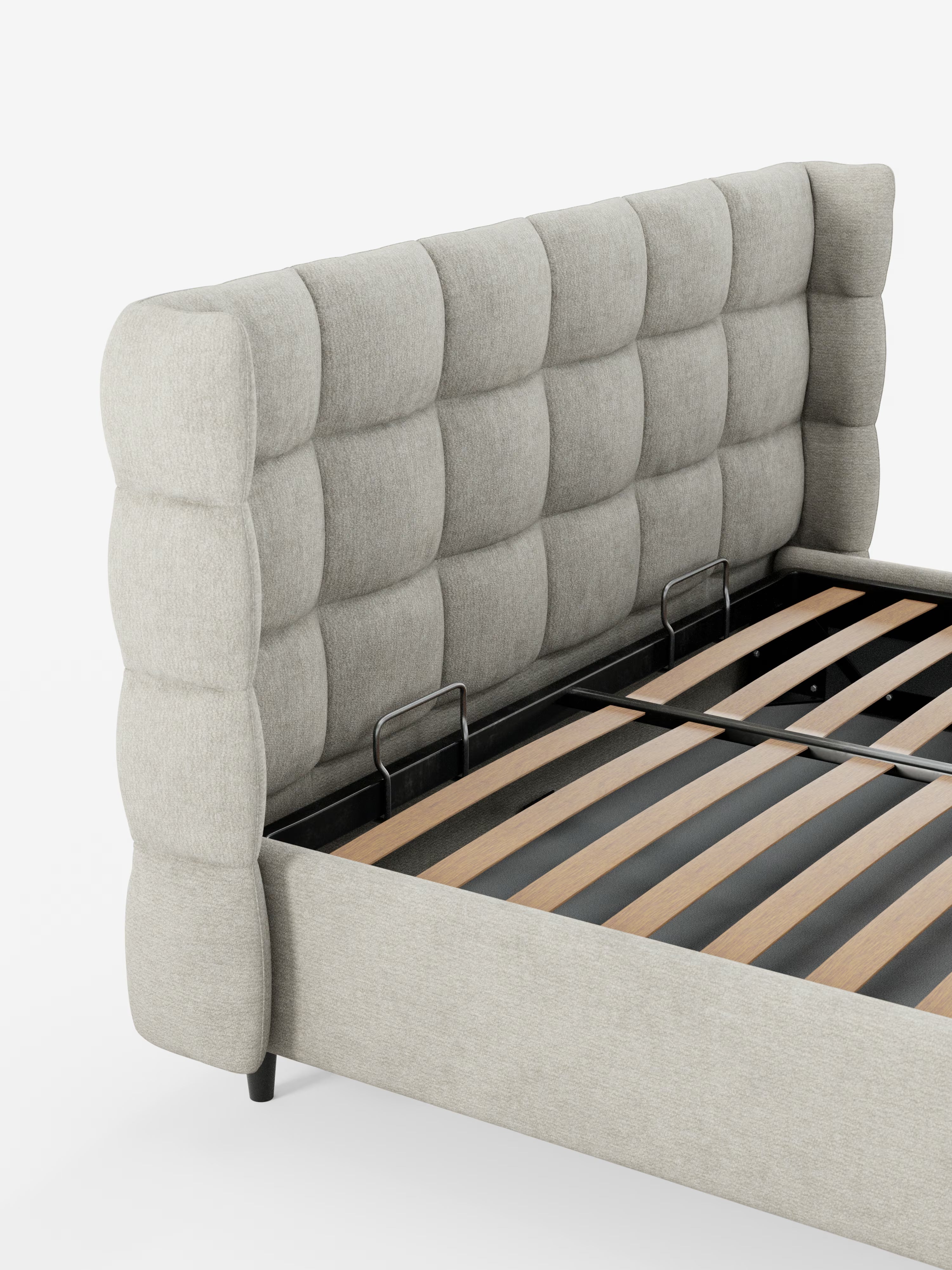 Un primo piano del letto imbottito RAGNAR con contenitore e testiera capitonné avvolgente di Letti.store mette in risalto la sua alta testiera capitonné in tessuto grigio chiaro, realizzata con un elegante materiale certificato Oeko-Tex® e doghe in legno. La testiera capitonné avvolgente presenta un aspetto trapuntato e imbottito con profonde rientranze quadrate. Questo moderno telaio del letto si staglia su uno sfondo bianco.