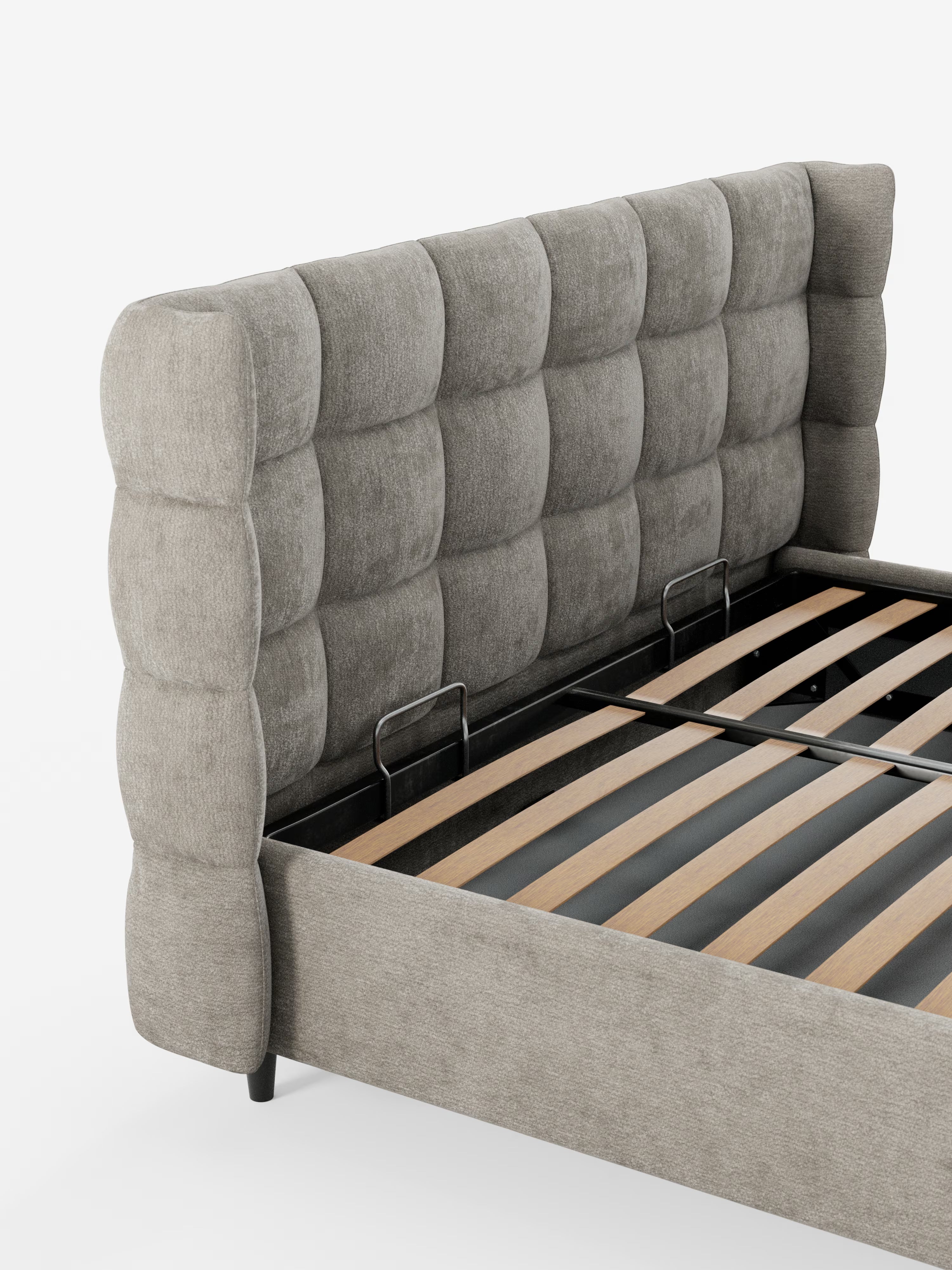 Il letto imbottito con contenitore RAGNAR di Letti.store presenta un’elegante testiera capitonné, alta e avvolgente, con imbottitura a quadri, rivestita in tessuto grigio certificato Oeko-Tex®. La sua robusta struttura comprende doghe in legno per il sostegno del materasso e barre di rinforzo in metallo, il tutto su uno sfondo bianco pulito.