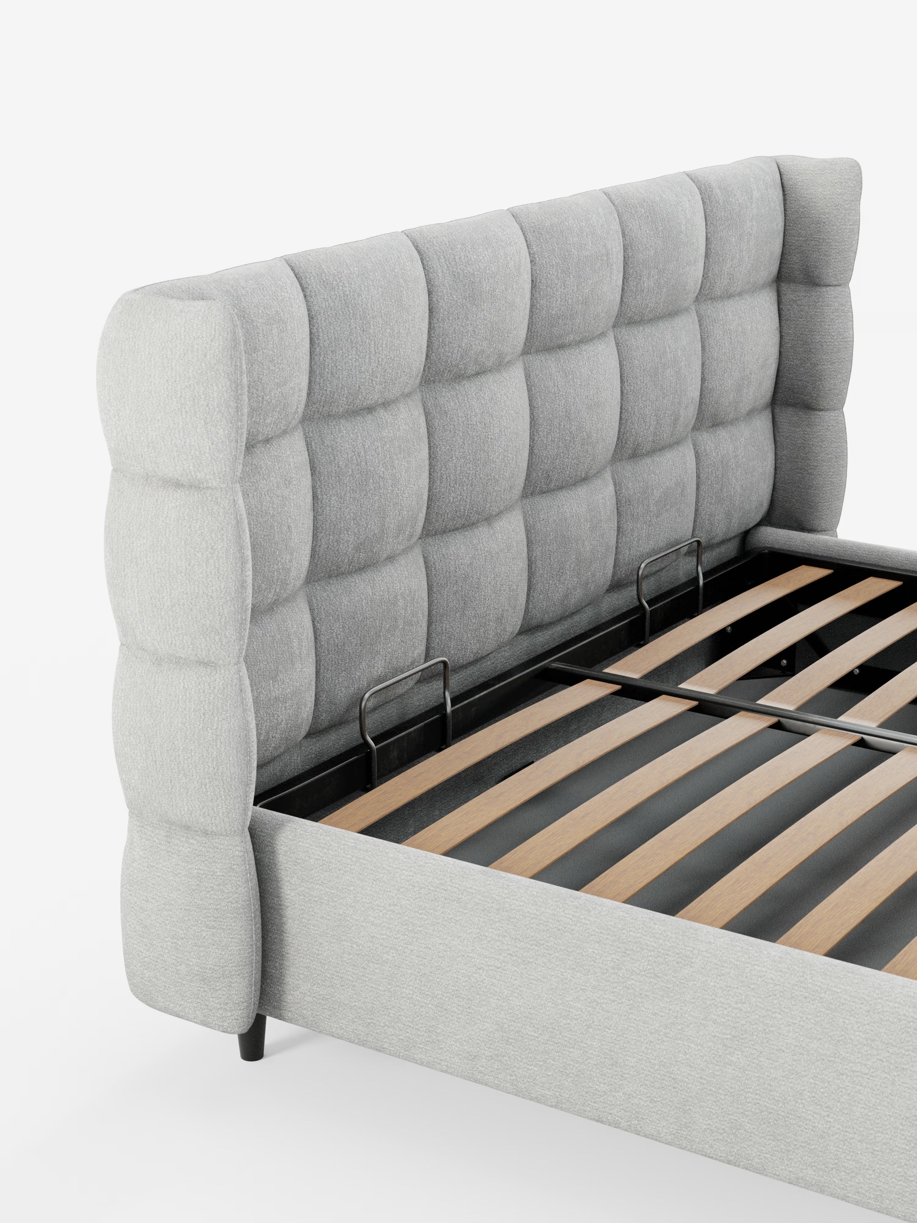 Un primo piano del letto imbottito con contenitore RAGNAR di Letti.store, che mette in risalto il suo design moderno con un’alta e morbida testiera capitonné avvolgente in tessuto grigio chiaro certificato Oeko-Tex® e doghe in legno a vista, su uno sfondo bianco a tinta unita. Non sono presenti né materasso né biancheria da letto.