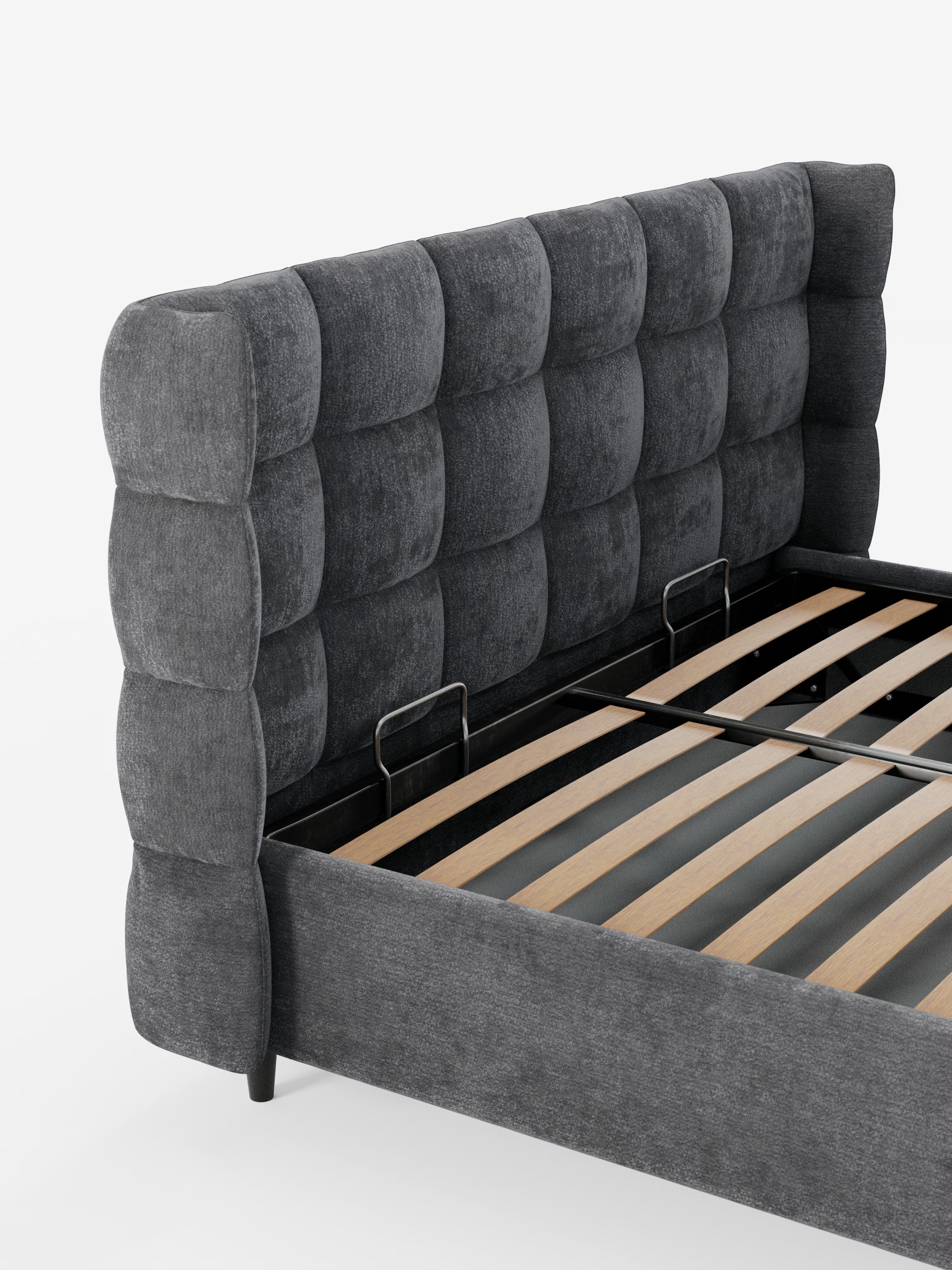 Un primo piano del letto imbottito RAGNAR con contenitore e testiera capitonné avvolgente di Letti.store, caratterizzato da un’alta testiera imbottita di colore grigio scuro con motivo a griglia, realizzata in elegante tessuto certificato Oeko-Tex®. All’interno del telaio del letto sono visibili i supporti a doghe in legno e due barre di sostegno centrali in metallo.