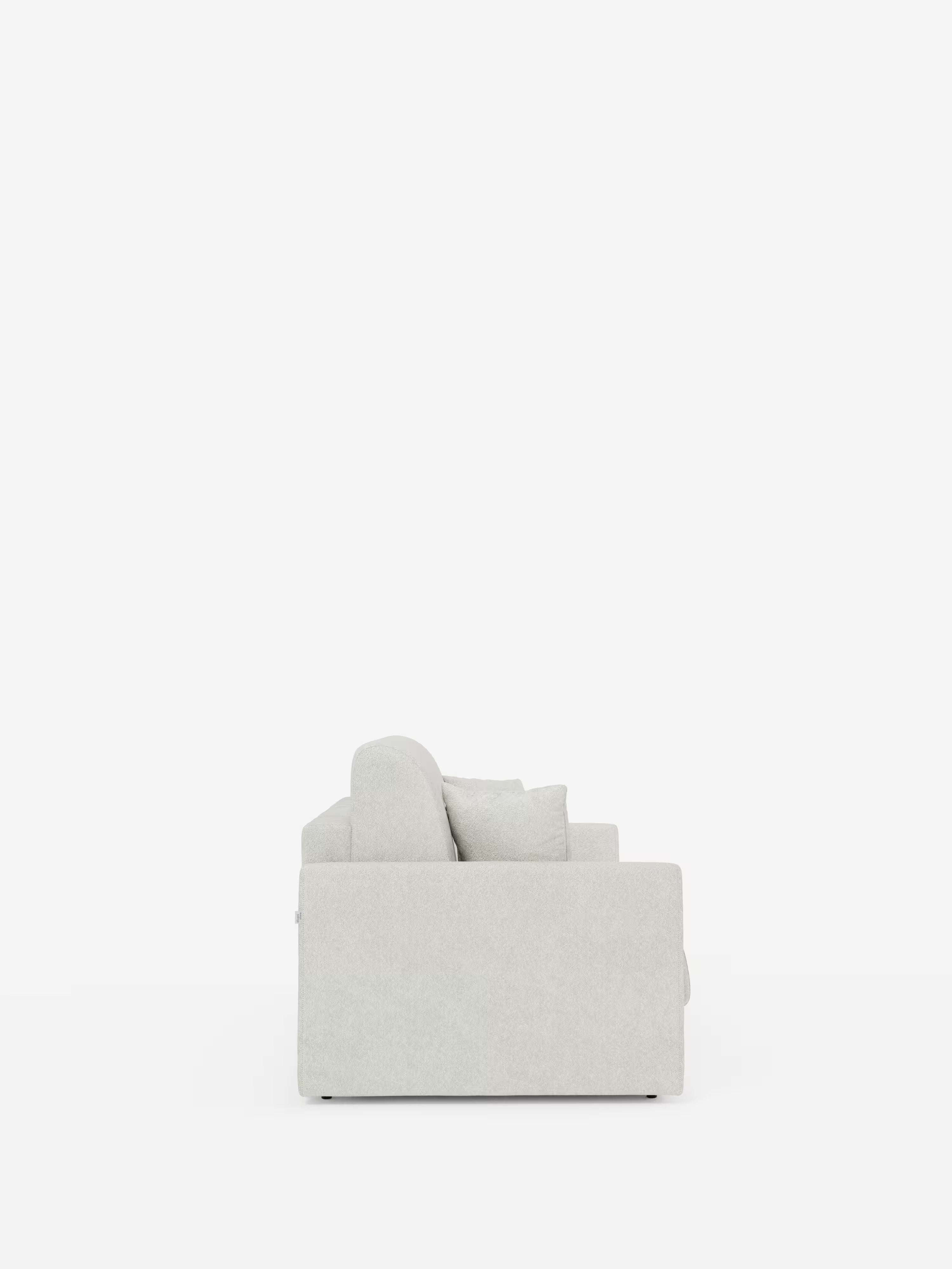 Una vista laterale del divano letto Tommy Divano a 2 e 3 posti matrimoniale di Divani.Store è raffigurata su uno sfondo bianco a tinta unita. Rivestito in tessuto T33 grigio chiaro, resistente alle macchie, simile al cotone e completamente sfoderabile, questo moderno divano letto presenta una silhouette pulita e squadrata con morbidi cuscini e braccioli dritti. Il suo design minimalista è privo di decorazioni o motivi visibili, sottolineando la semplicità e lo stile contemporaneo.