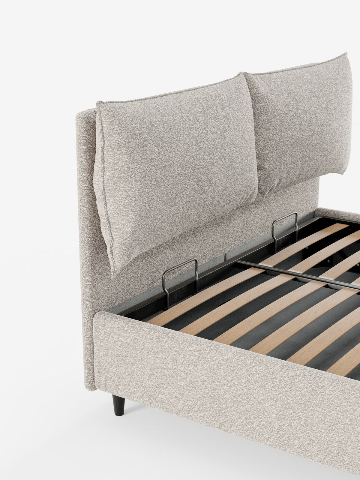 Il letto imbottito con contenitore ZAYRON di Letti.store presenta un design moderno in tessuto beige chiaro certificato Oeko-Tex®. La sua testiera alta e imbottita include due grandi cuscini morbidi e regolabili. La struttura del letto è sostenuta da eleganti gambe nere e presenta doghe in legno a vista quando il materasso non è posizionato. Lo sfondo è bianco a tinta unita.