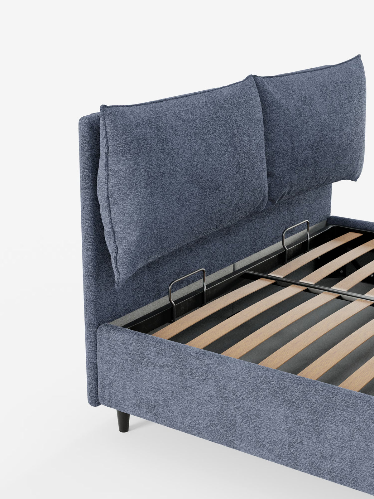 Viene mostrata una vista parziale del letto imbottito ZAYRON di Letti.store, caratterizzato da un tessuto blu certificato Oeko-Tex®, due grandi cuscini imbottiti regolabili sulla testiera, un pratico vano portaoggetti, doghe in legno per il sostegno del materasso e montanti in metallo nero. Il letto dal design moderno poggia su corte gambe nere su uno sfondo bianco.