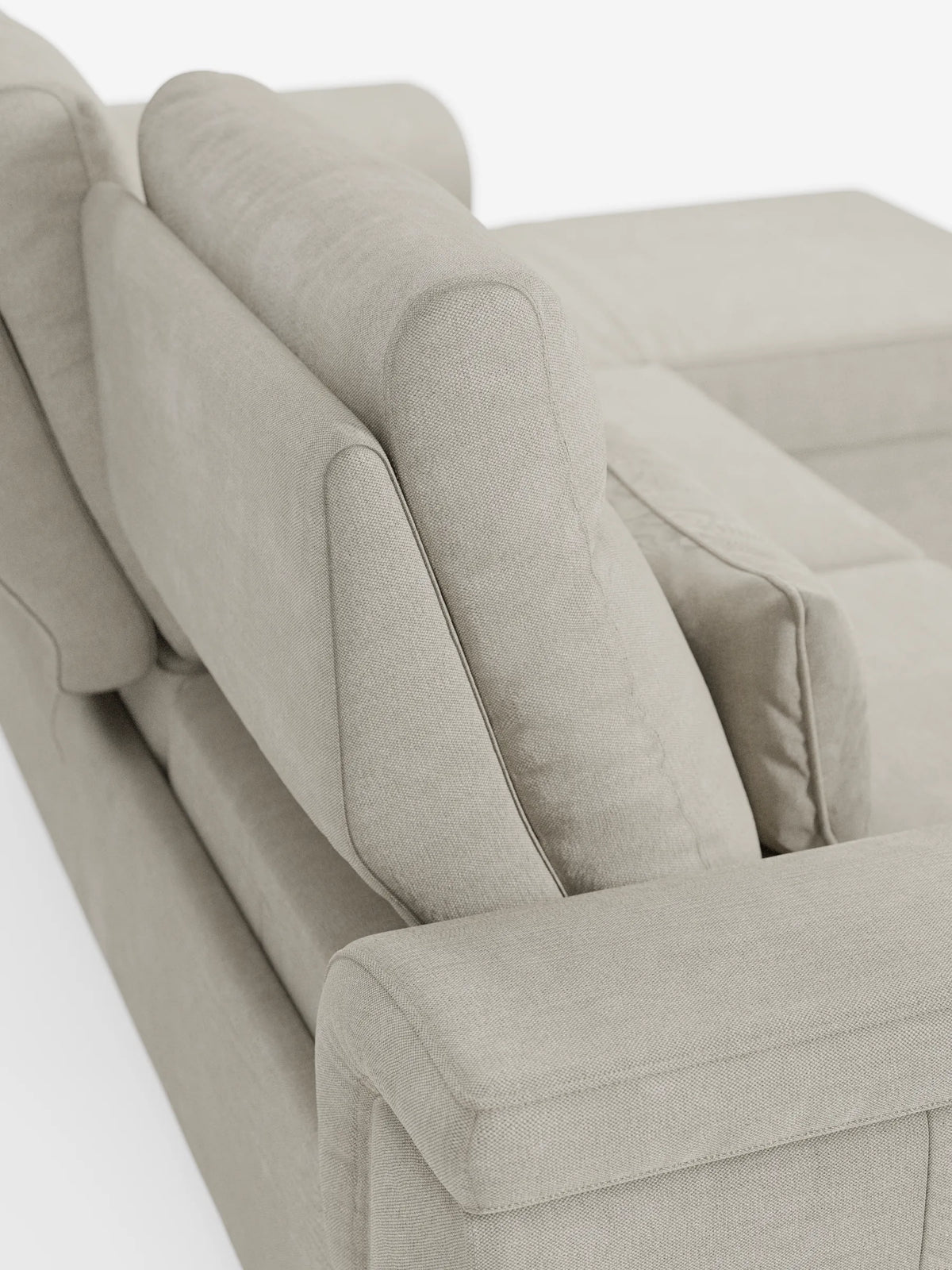 Un divano letto angolare Ischia color beige chiaro con schienali scorrevoli e rivestimento in tessuto testurizzato, ripreso da dietro per mostrare i cuscini imbottiti dello schienale e l'ampio bracciolo su uno sfondo bianco a tinta unita.