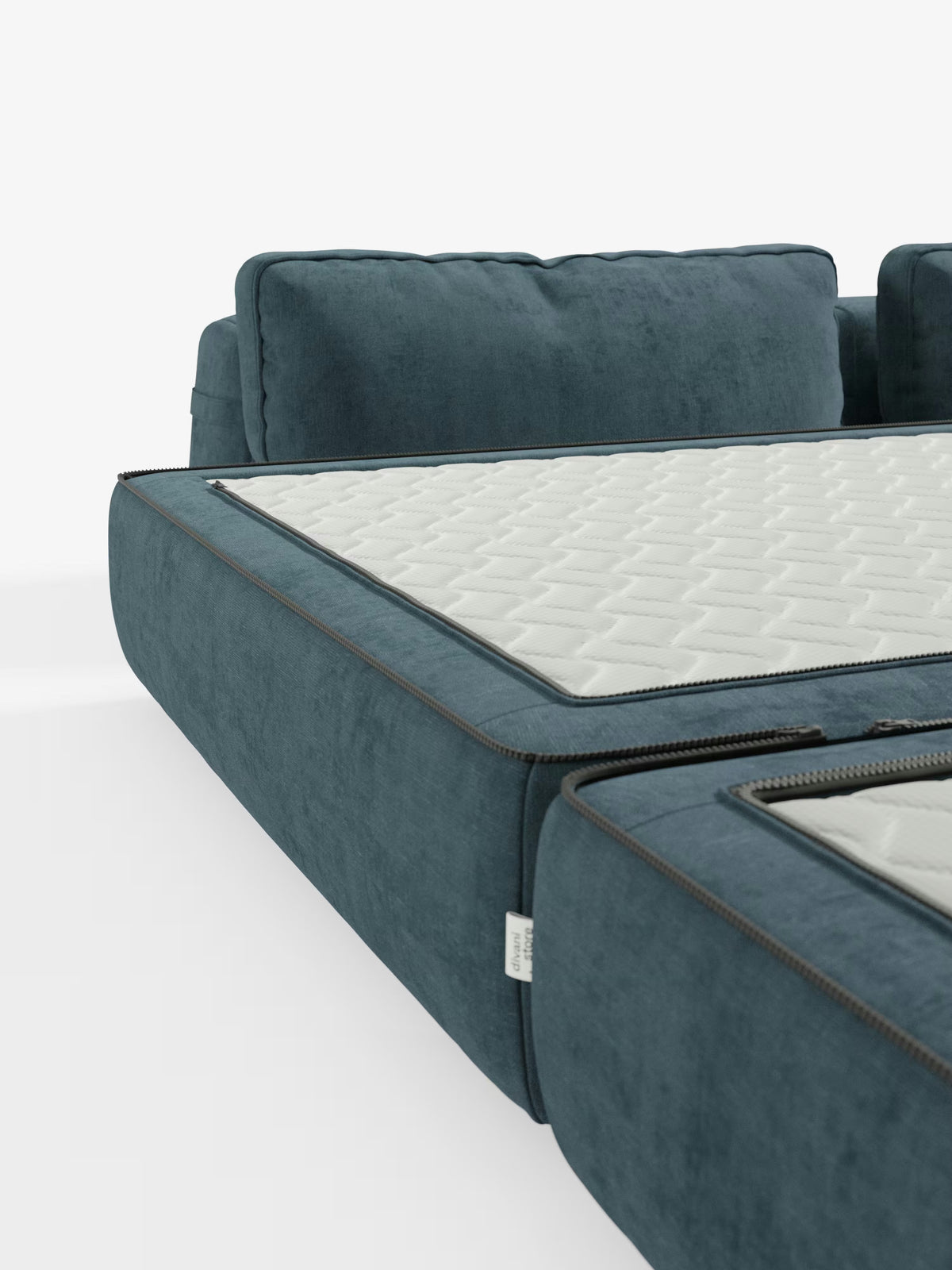 Primo piano del moderno divano letto matrimoniale Rift blu di Divani.Store, caratterizzato da schienali regolabili e da un lussuoso materasso bianco trapuntato in memory foam alto 24 cm (parzialmente aperto con cerniera) posizionato sopra il divano. I morbidi cuscini ne accentuano il comfort, mentre lo sfondo bianco e pulito ne esalta il fascino contemporaneo. Questo divano letto trasformabile a 2 o 3 posti, rivestito in tessuto T31 antimacchia, è ideale per ambienti funzionali ed eleganti.