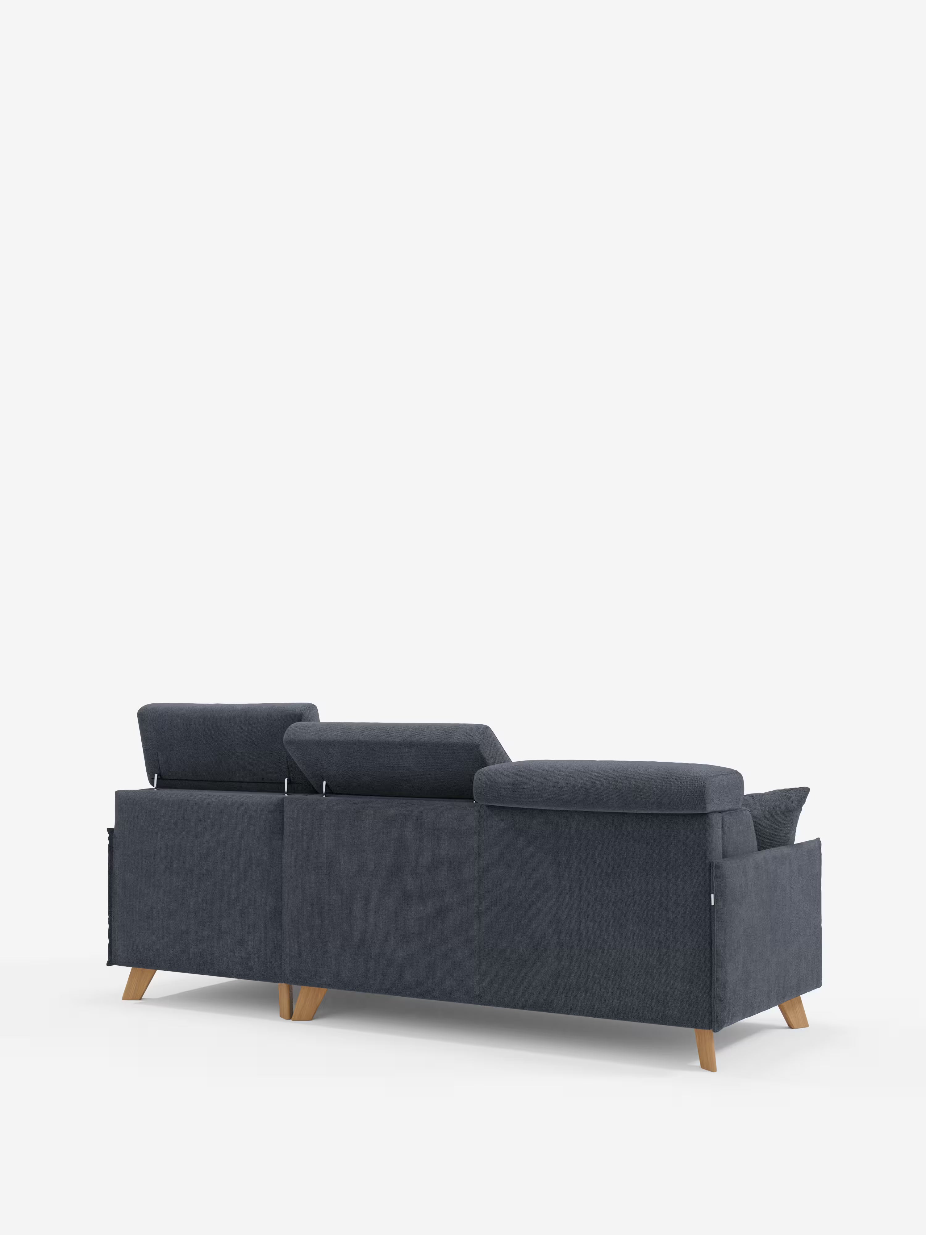 Un divano moderno grigio scuro — Sole Divano letto matrimoniale angolare con penisola contenitore e poggiatesta reclinabili di Divani.Store — è ripreso di spalle da un'angolazione obliqua. Caratterizzato da uno stile scandinavo con poggiatesta regolabili, linee pulite e dritte e gambe in legno, il divano, rivestito in tessuto smacchiabile T23, è esposto su uno sfondo bianco a tinta unita.