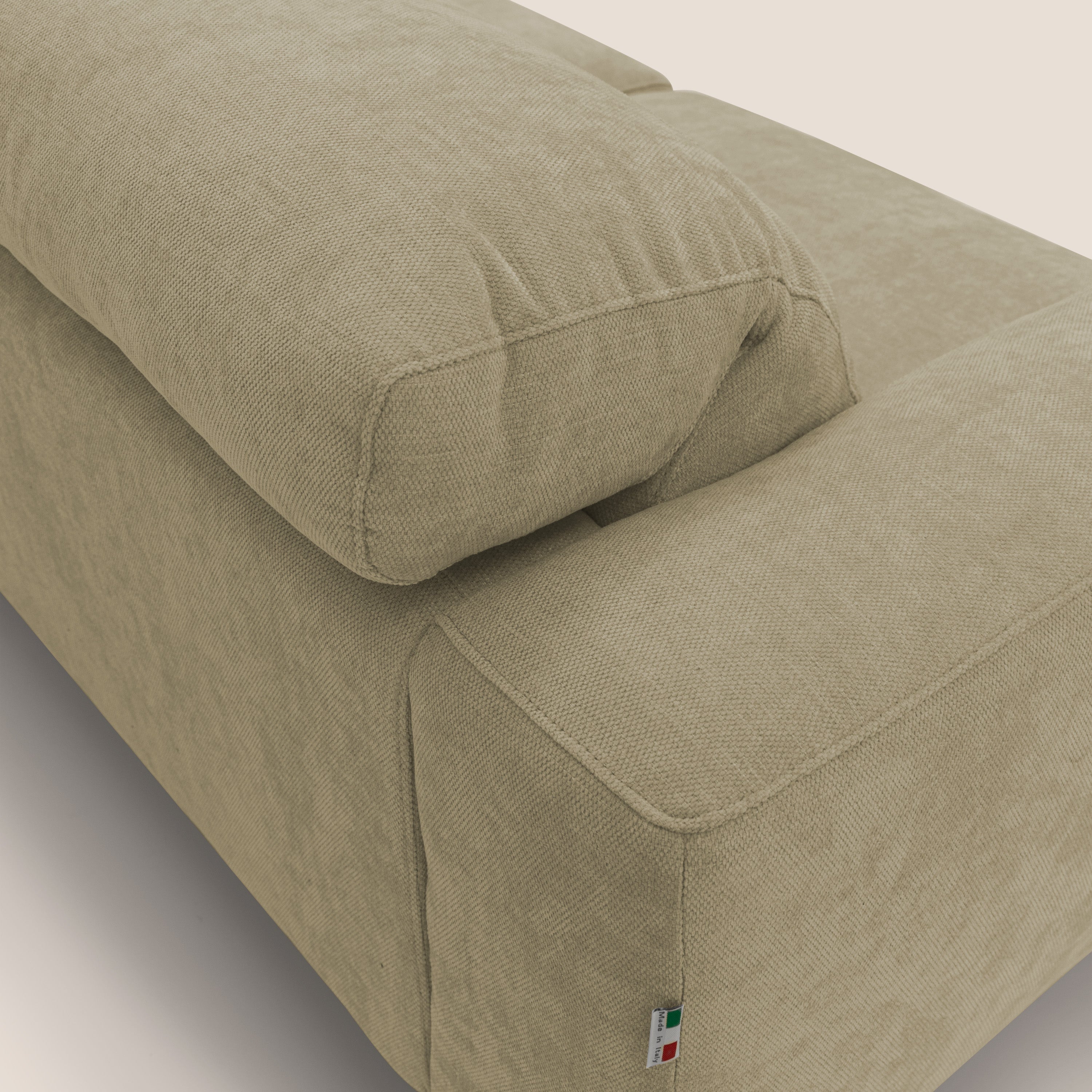 Primo piano del divano Sakura in piuma d'oca di Divani.Store, caratterizzato da un tessuto impermeabile T14 fiammato beige, da dettagliati cuscini del bracciolo e dello schienale e da una targhetta con i colori della bandiera messicana cucita sul bracciolo.