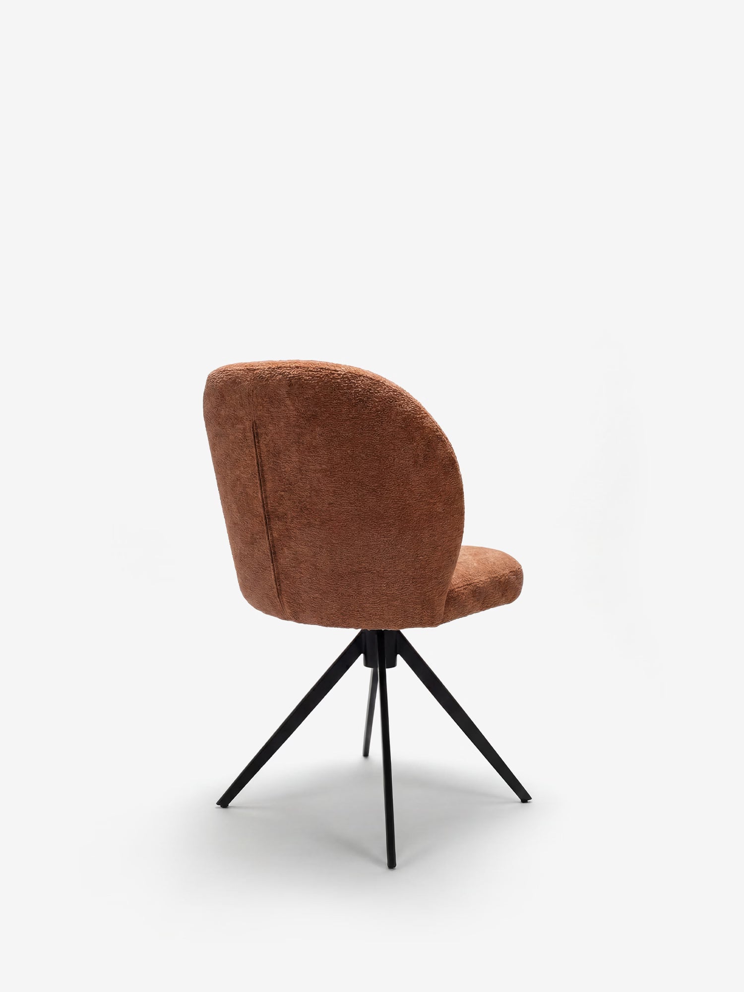 La sedia imbottita Alba di Divani.Store presenta una seduta e uno schienale arrotondati, di colore marrone, con effetto cotone certificati OEKO-TEX®, oltre a quattro sottili gambe in metallo nero che si allargano verso l’esterno, il tutto su uno sfondo bianco a tinta unita.