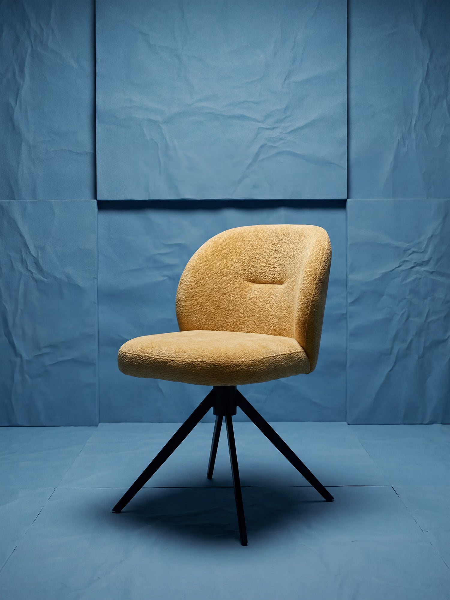 La sedia imbottita Alba in tessuto effetto cotone certificato OEKO-TEX® di Divani.Store presenta un design arrotondato di colore giallo, con una seduta morbida e una base in metallo nero. I pannelli in carta blu testurizzata e l’illuminazione soffusa ne esaltano lo stile audace e moderno.