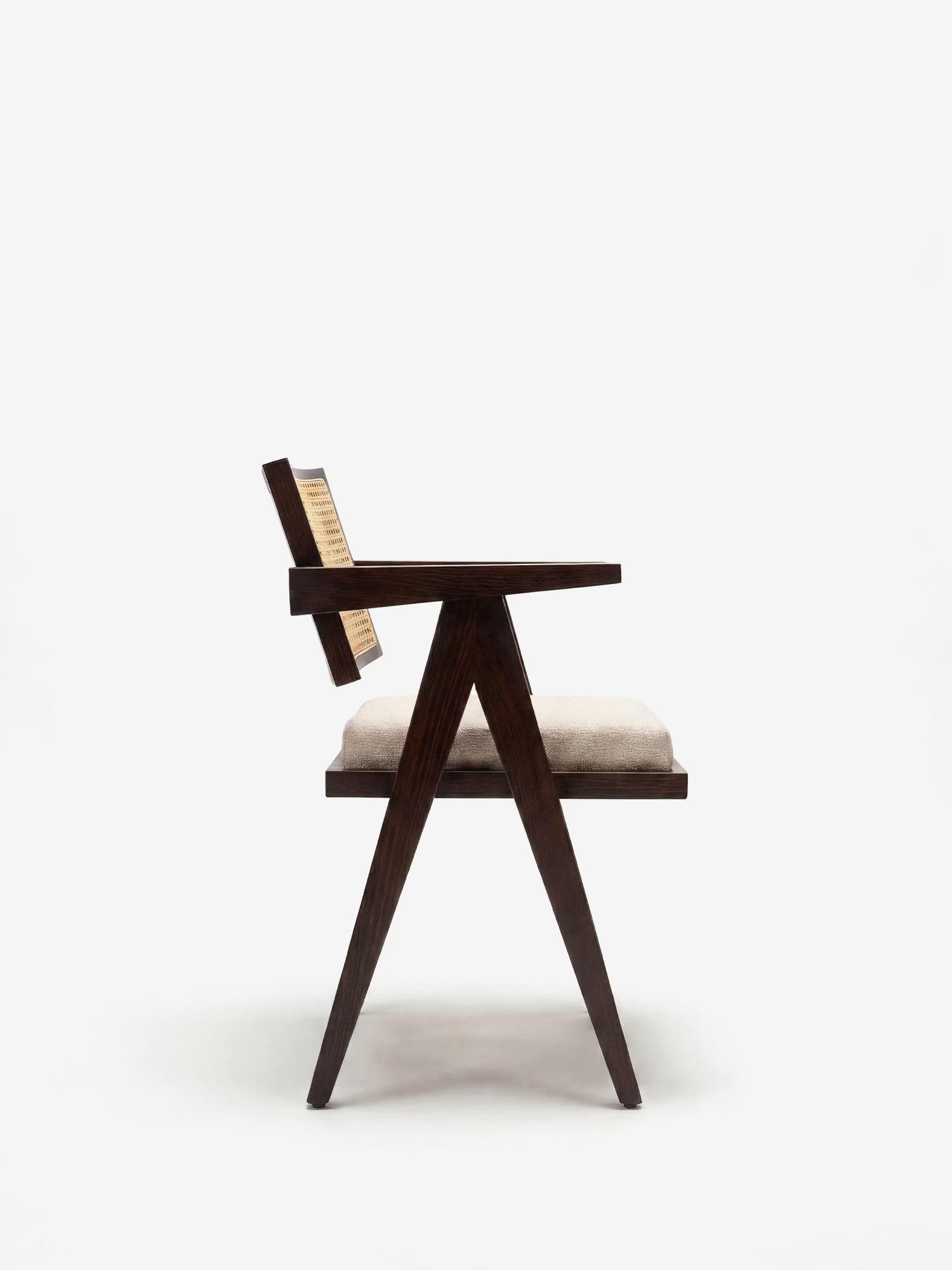 Una vista laterale della sedia con braccioli Antea di Divani.Store, realizzata in legno massello wengé, mostra uno schienale angolato in rattan, i braccioli e una seduta imbottita in misto cotone beige. Le gambe formano una figura triangolare su uno sfondo bianco a tinta unita.