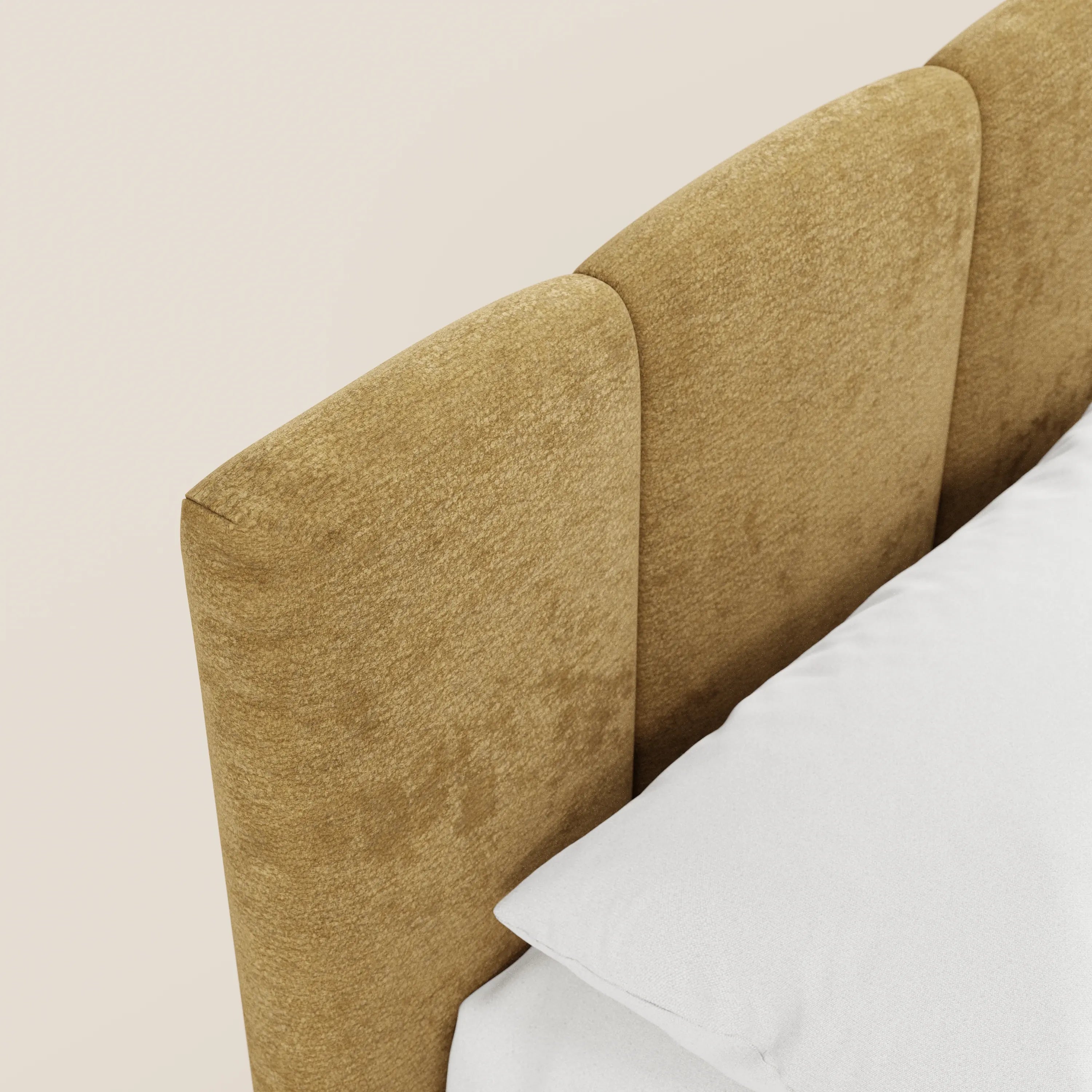 Un primo piano del letto imbottito con contenitore ARKAM di Letti.store mette in risalto la testiera rivestita in giallo senape con tre sezioni imbottite verticali in tessuto Oeko-Tex®, la biancheria da letto bianca e una parete beige, per un look moderno in stile shabby chic.