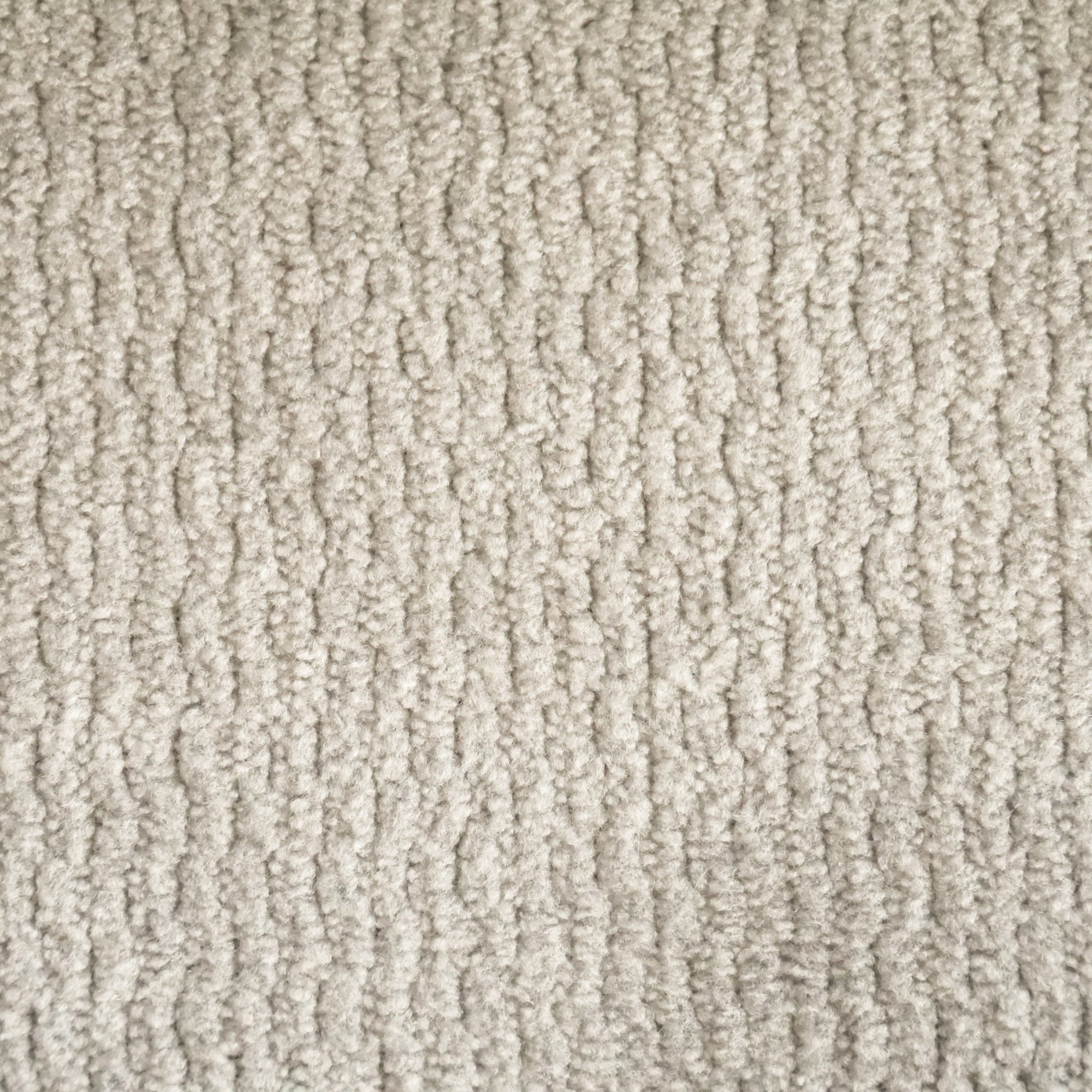 Primo piano del tappeto Personalizzazione in T32 di Divani.Store, caratterizzato da un colore beige chiaro e da fibre a trama fitta e a file verticali. Il sottile motivo in rilievo aggiunge consistenza alla superficie neutra, morbida e uniforme.