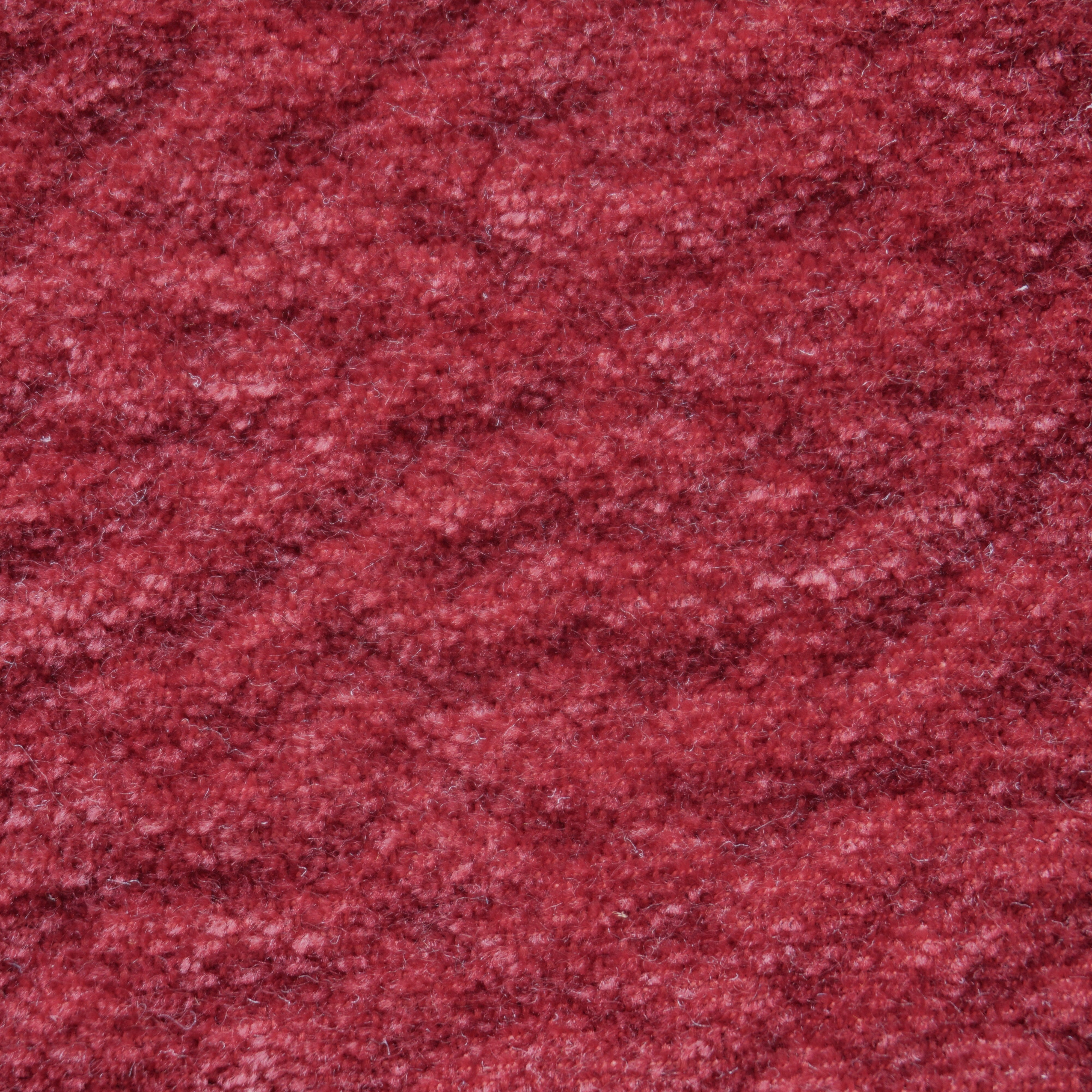 Primo piano di Personalizzazione in T27 di Divani.Store: un tessuto morbido e strutturato in rosso intenso, dall'aspetto felpato e accogliente. Le fibre sfocate creano un motivo irregolare e sottili variazioni di tonalità per una maggiore eleganza.