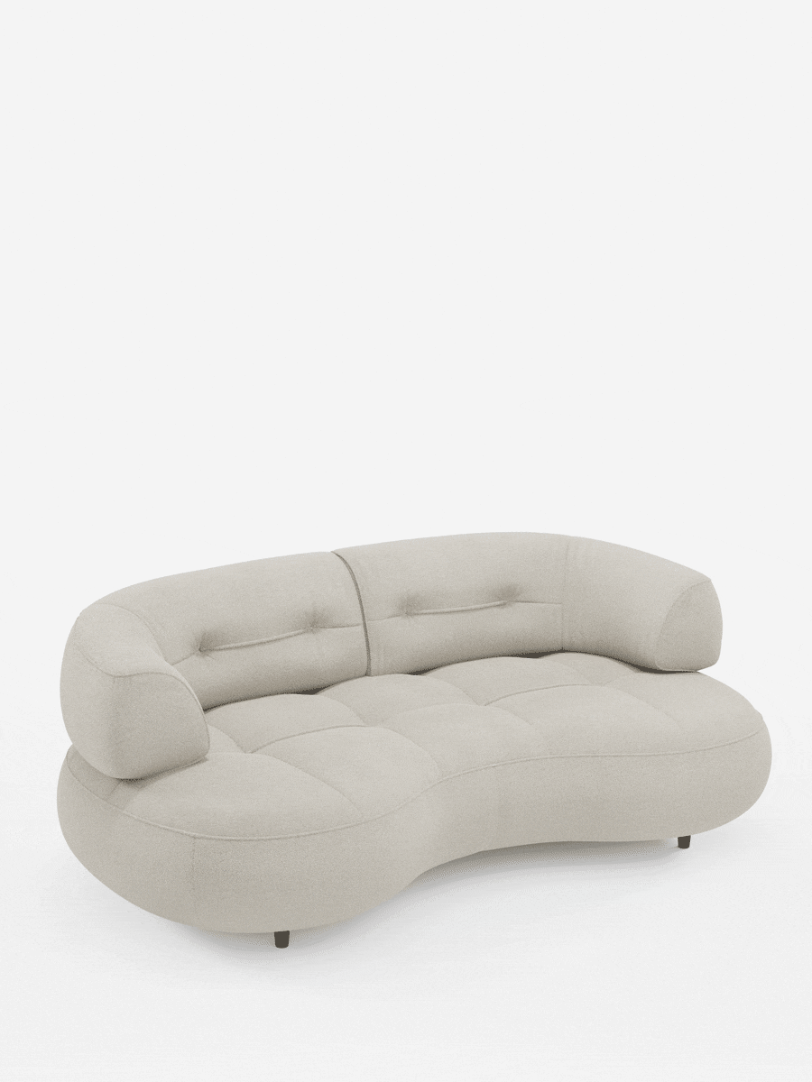 A Croissant: divano curvo a fagiolo a 3 posti con schienali traslanti, rivestito in morbido tessuto effetto cotone smacchiabile T33: un divano a forma di fagiolo in tessuto testurizzato beige chiaro con dettagli trapuntati e gambe scure su sfondo bianco.
