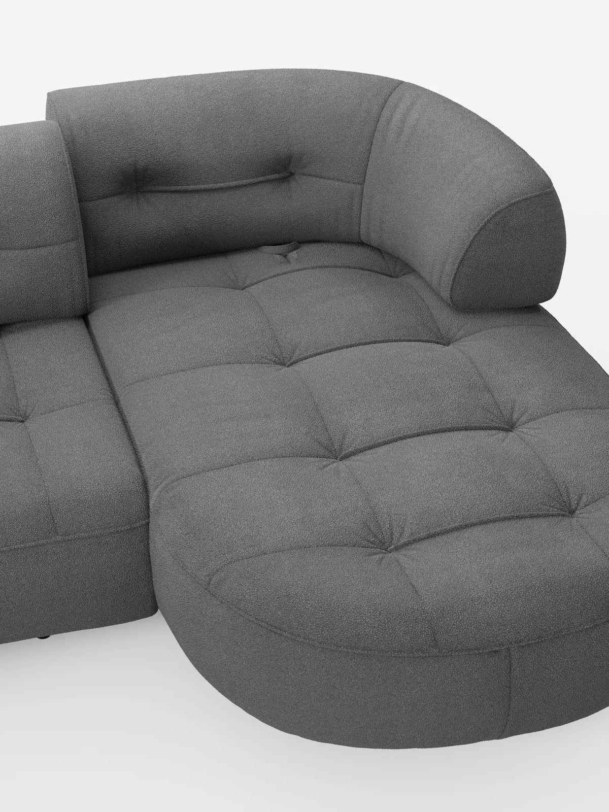 Un divano angolare Croissant grigio, dal design a forma di fagiolo, con schienali scorrevoli in morbido tessuto effetto cotone smacchiabile T33, dotato di seduta imbottita e trapuntata, schienali curvi e bordi arrotondati e modulari su uno sfondo bianco.