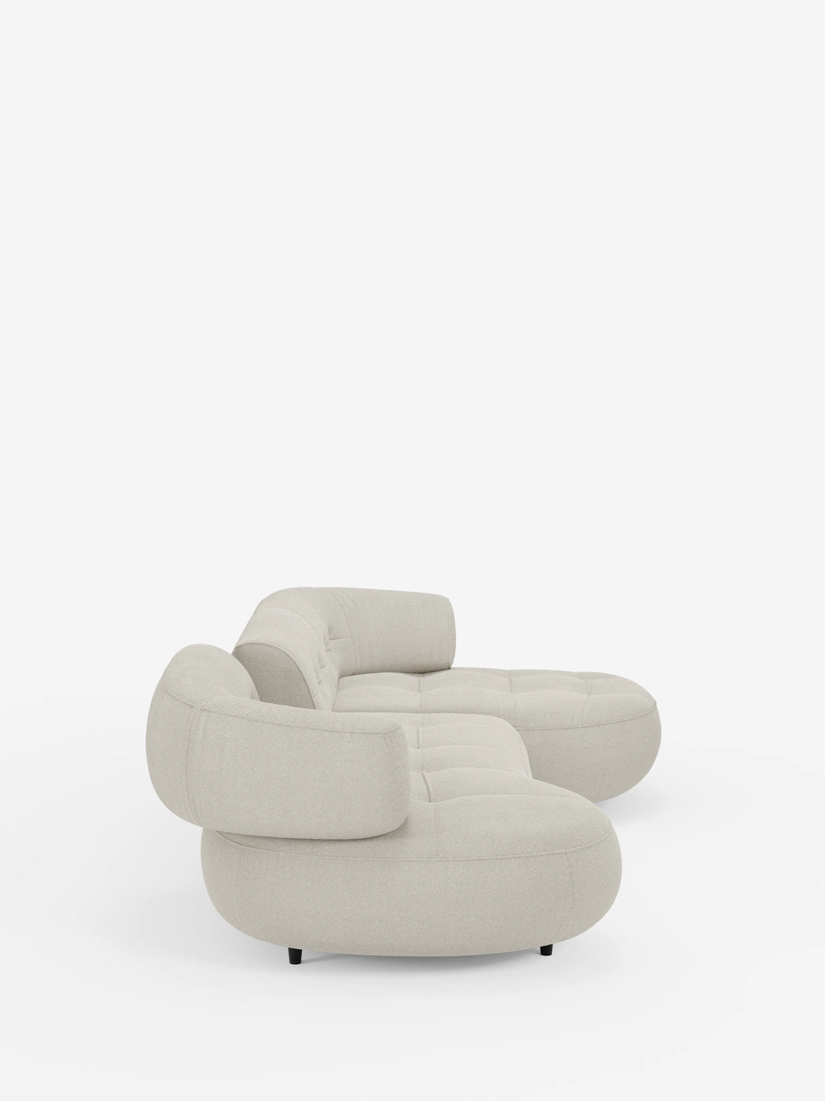 Un divano angolare Croissant dal design a fagiolo e schienali scorrevoli in morbido tessuto effetto cotone smacchiabile T33, caratterizzato da un tessuto beige chiaro con trama in rilievo, cuscini curvi dal profilo basso e schienali arrotondati su uno sfondo bianco.