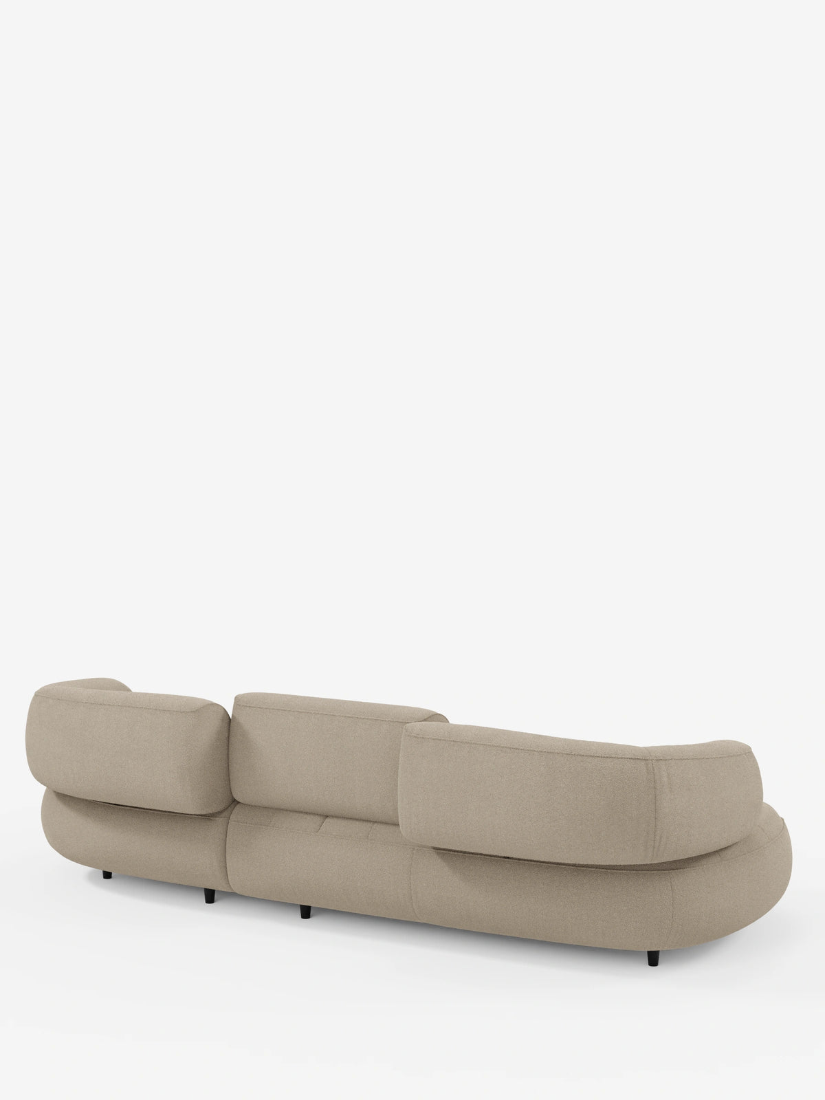 Un divano angolare Croissant beige dal design organico a forma di fagiolo, con schienali scorrevoli in morbido tessuto effetto cotone smacchiabile T33, ripreso da dietro con bordi arrotondati, cuscini spessi e piccole gambe scure affusolate.