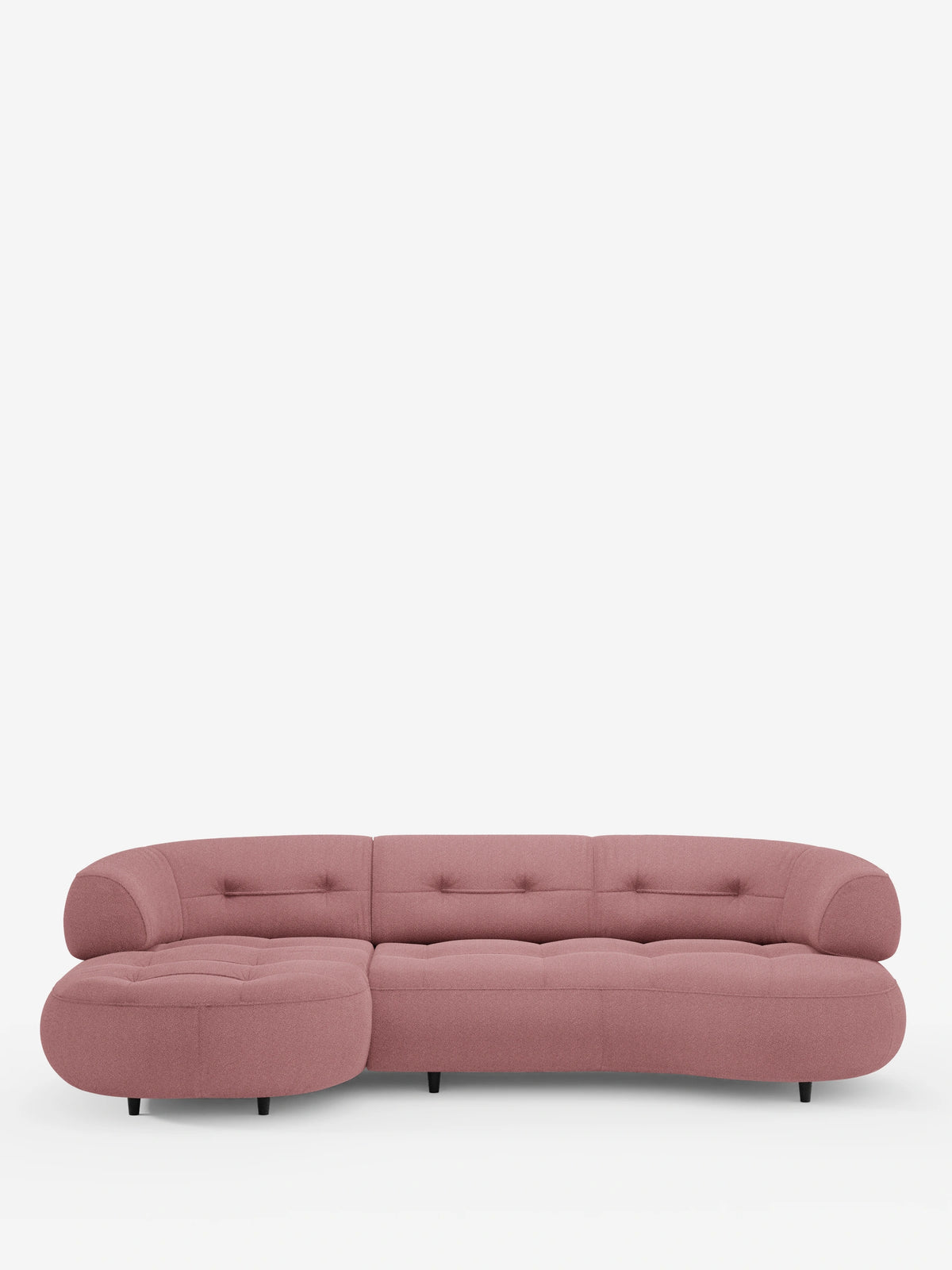 Un divano angolare contemporaneo a forma di fagiolo, il “Croissant”, con schienali scorrevoli in morbido tessuto effetto cotone smacchiabile T33 color rosa polveroso, con dettagli trapuntati, braccioli arrotondati e gambe nere dal profilo basso.