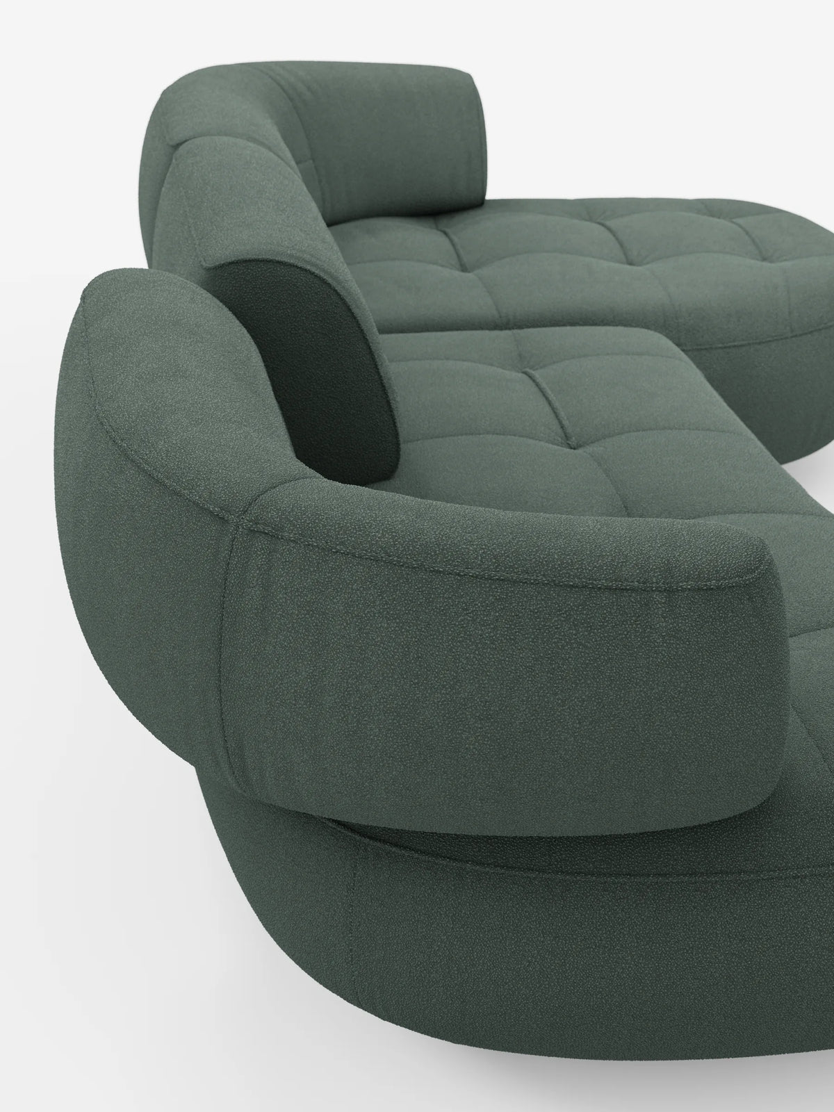 Un divano angolare Croissant color verde salvia, dal design a fagiolo, con schienali traslanti in morbido tessuto effetto cotone smacchiabile T33, caratterizzati da schienali arrotondati e dal profilo ribassato, una finitura testurizzata e una seduta trapuntata su fondo bianco.