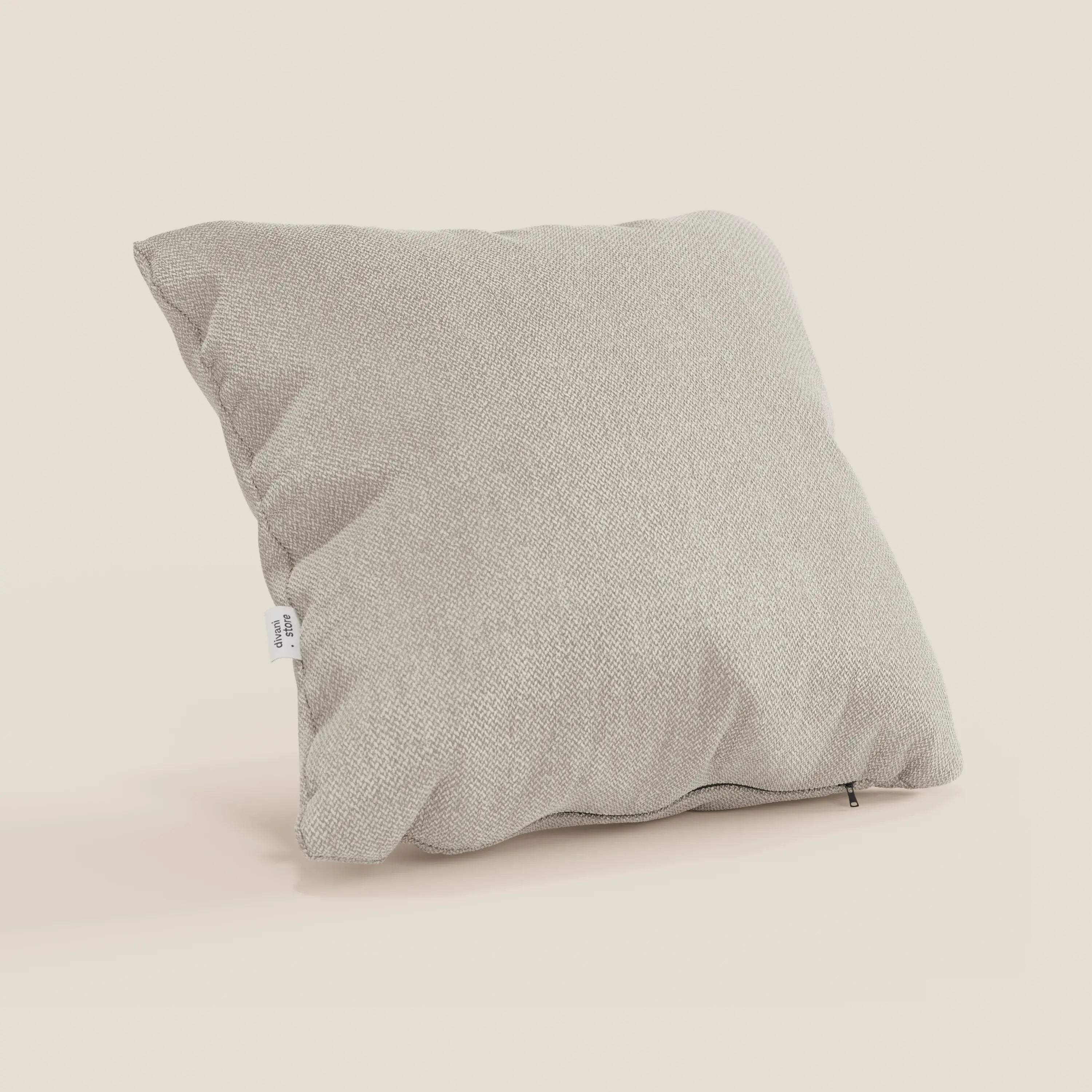 Il cuscino Sogno di Divani.Store, presentato in tessuto panna SMACCHIABILE T05, presenta una trama intrecciata beige chiaro con una piccola etichetta bianca e una cerniera scura lungo il bordo inferiore. Disponibile in vari colori.