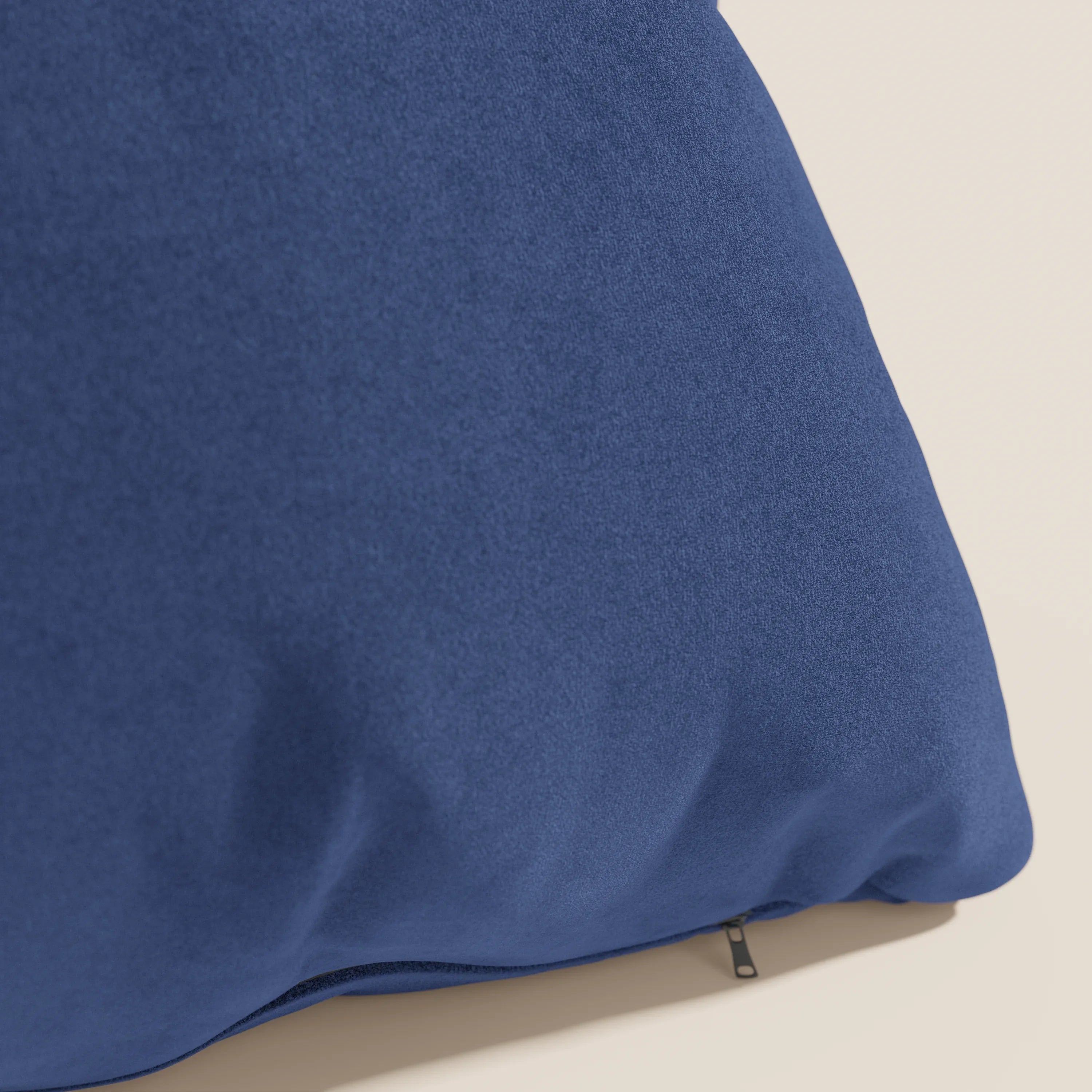 Il cuscino Jazz di Divani.Store, qui presentato in microfibra tecnica antimacchia blu T11, presenta una texture morbida e liscia effetto alcantara e una discreta cerniera lungo il bordo inferiore su uno sfondo chiaro.