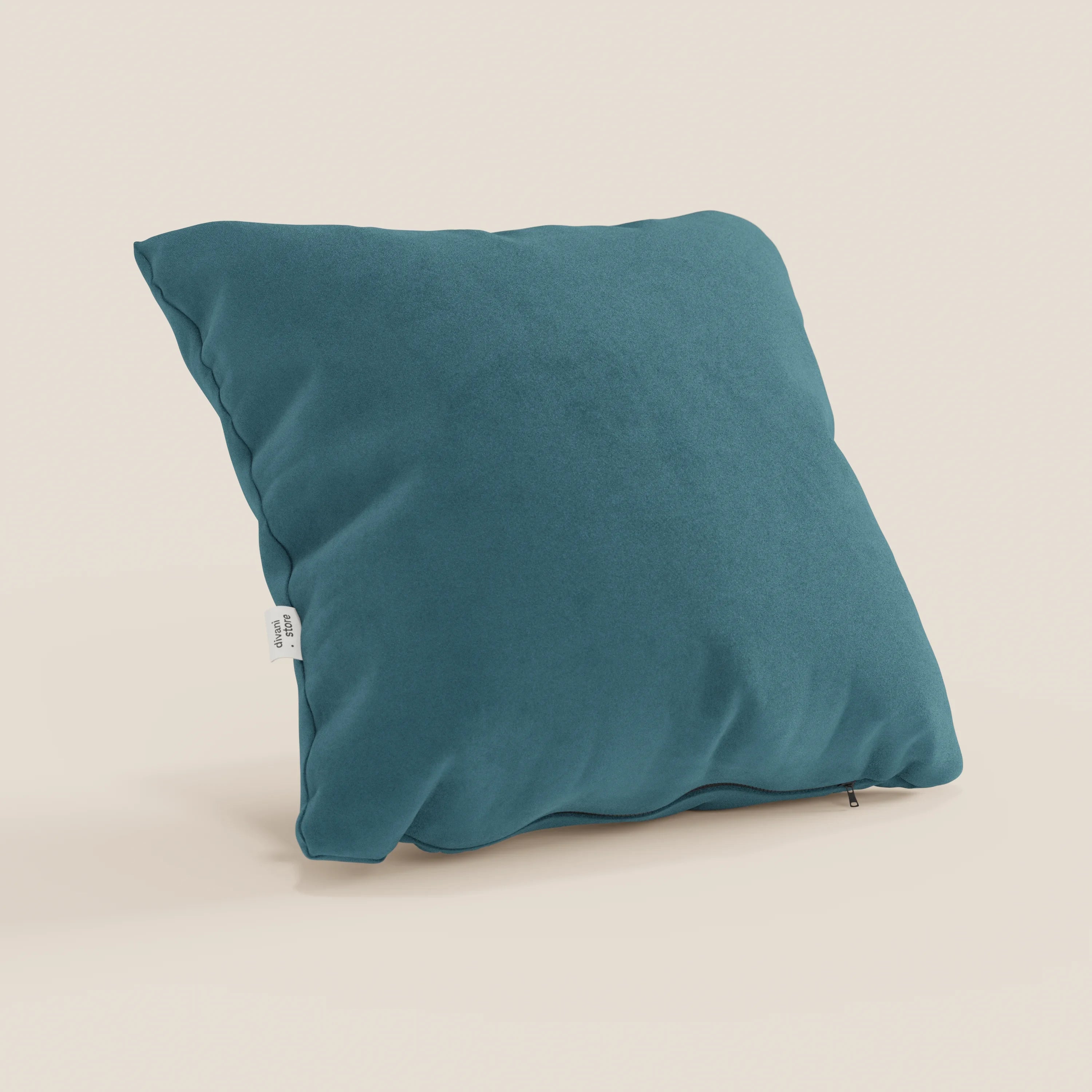 Il cuscino Jazz di Divani.Store in T11 petrolio si staglia su uno sfondo beige chiaro. Realizzato in microfibra tecnica antimacchia, ha una consistenza morbida, pieghe delicate, un'etichetta laterale bianca e una sottile cerniera sul fondo.