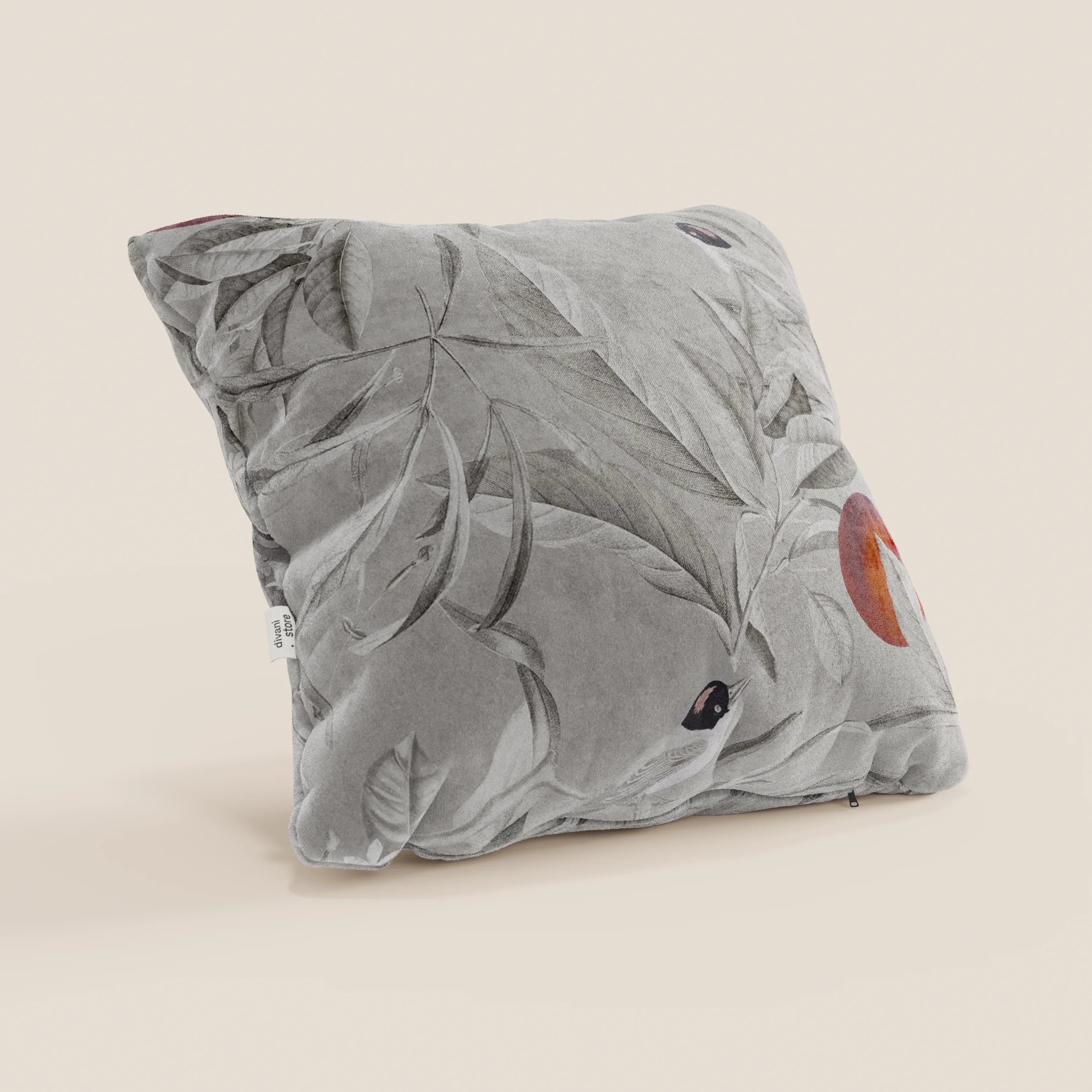 La collezione Lemon elegante di cuscini a fantasia in velluto impermeabile grigio di Divani.Store presenta un cuscino quadrato grigio con una stampa botanica, grandi foglie morbide e tocchi di arancione e viola scuro, etichetta visibile a sinistra su uno sfondo semplice.