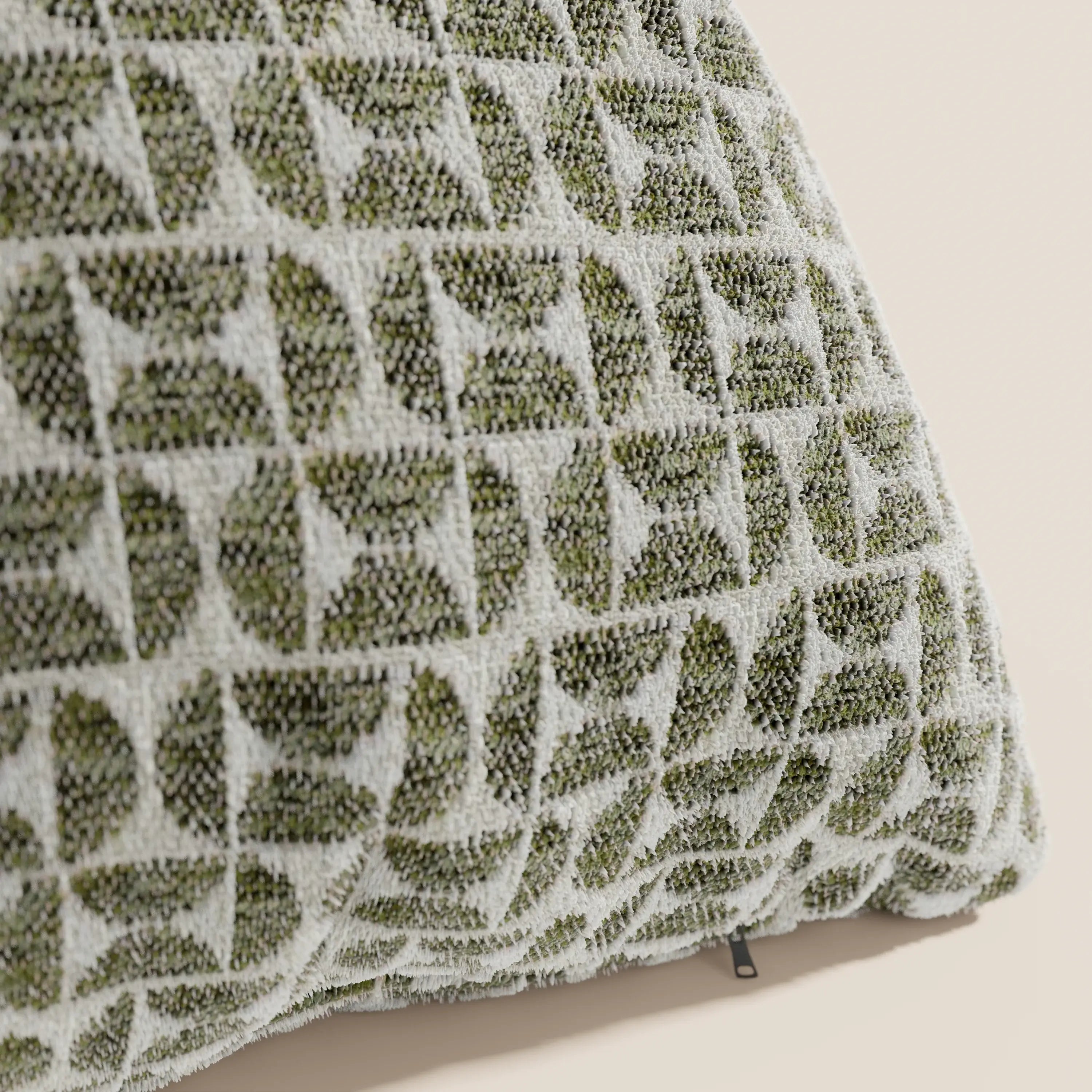 Primo piano del cuscino Naxos Decoro 45x45 in lino di Divani.Store, realizzato in lino trapuntato con un motivo geometrico a foglie verde e bianco su sfondo chiaro e rifinito con una piccola etichetta nera sulla cucitura.