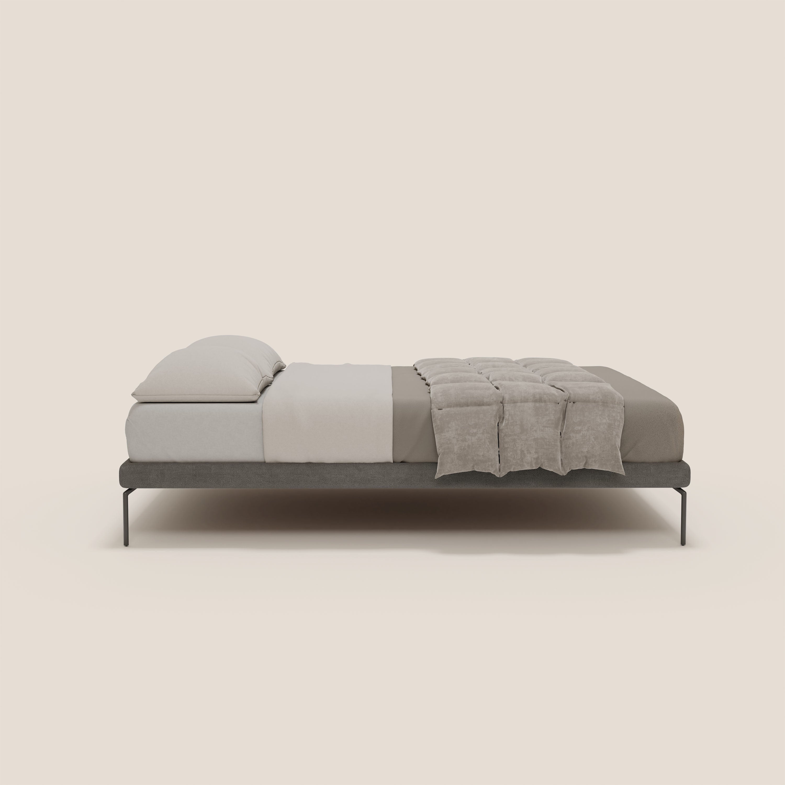 Il sommier sfoderabile Ring di Letti.store è caratterizzato da una struttura bassa in tessuto impermeabile T14 grigio scuro e da gambe nere alte 24 cm, su uno sfondo beige con lenzuola bianche e una coperta tortora ai piedi, che ne sottolineano il design minimalista italiano.