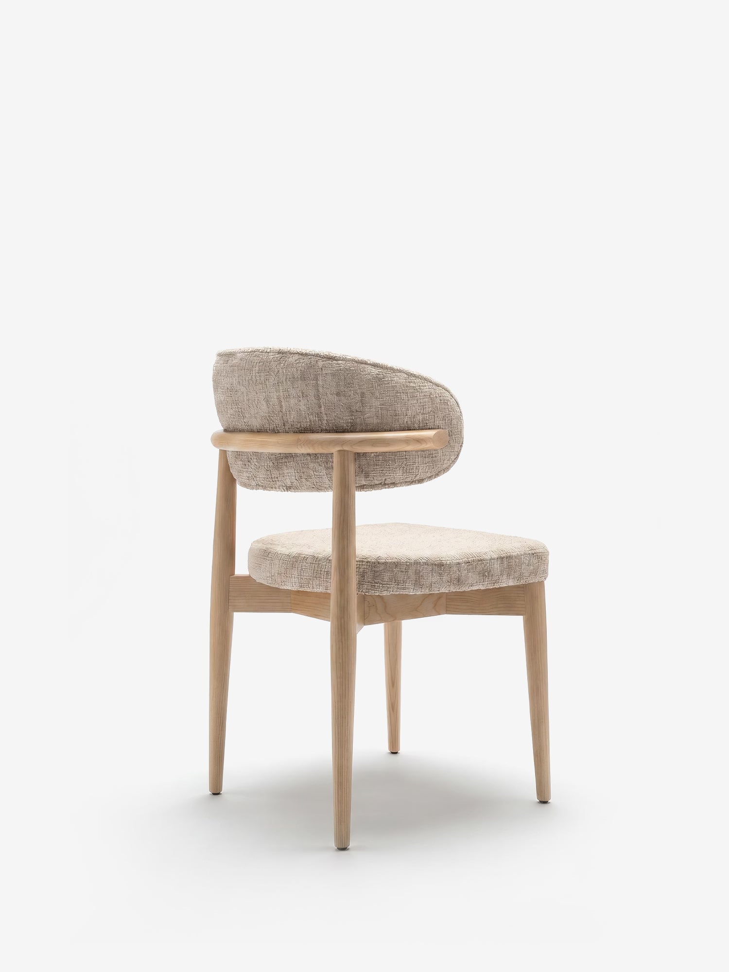 La sedia imbottita Dafne di Divani.Store presenta una struttura in rovere naturale massiccio con gambe arrotondate e uno schienale curvo, rivestita in tessuto ciniglia certificato OEKO-TEX®, qui raffigurata vista da dietro su uno sfondo bianco.