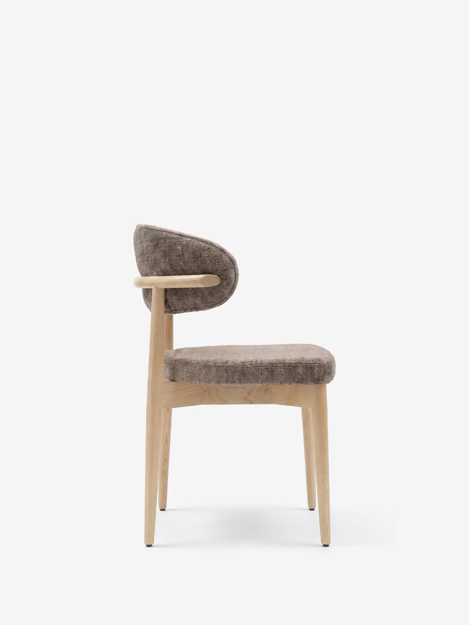 Vista laterale della sedia imbottita Dafne di Divani.Store, caratterizzata da gambe e struttura in rovere massello naturale, con seduta e schienale curvi rivestiti in ciniglia certificata OEKO-TEX® di colore marrone. Design minimalista con bordi smussati su sfondo bianco.