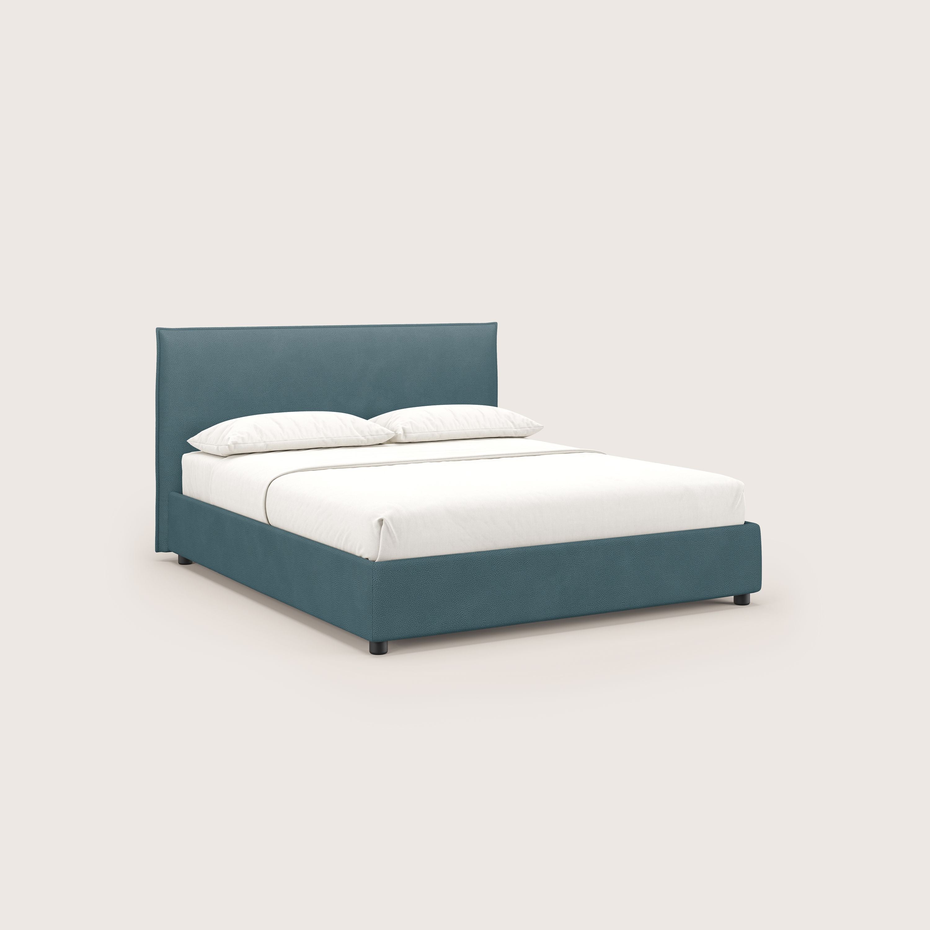 Il letto contenitore Nina di Letti.store, in smacchiabile pelle di microfibra petrolio, presenta un design minimale con un'alta testata rettangolare, un materasso bianco e due cuscini impilati su uno sfondo beige chiaro.