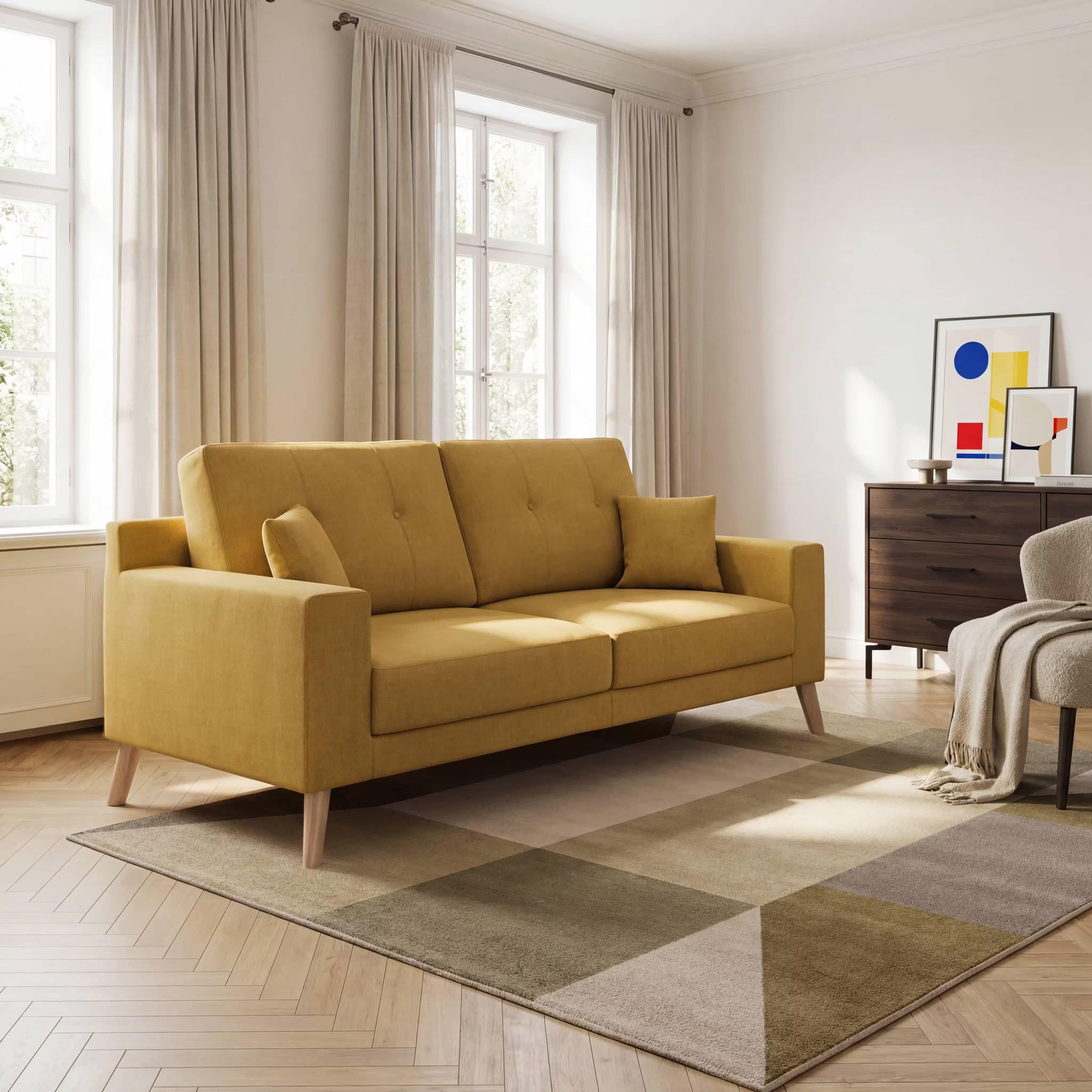 Soggiorno moderno con divano moderno Divani.Store Danish in tessuto morbido impermeabile T02 giallo, due cuscini coordinati, gambe in legno chiaro, ampie finestre con tende trasparenti, tappeto geometrico beige, credenza in legno, opere d'arte astratta e un'accogliente poltrona beige.