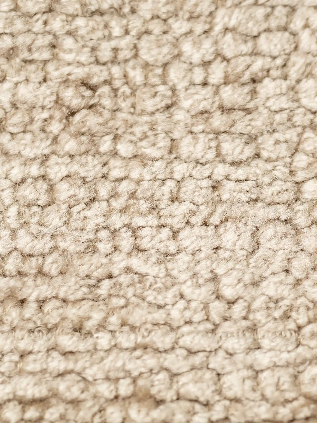 Primo piano del tessuto S02 ELITE, un tessuto ciniglia bouclé beige dalla trama spessa e strutturata, caratterizzato da morbidi anelli fitti che creano un effetto granuloso e tridimensionale.