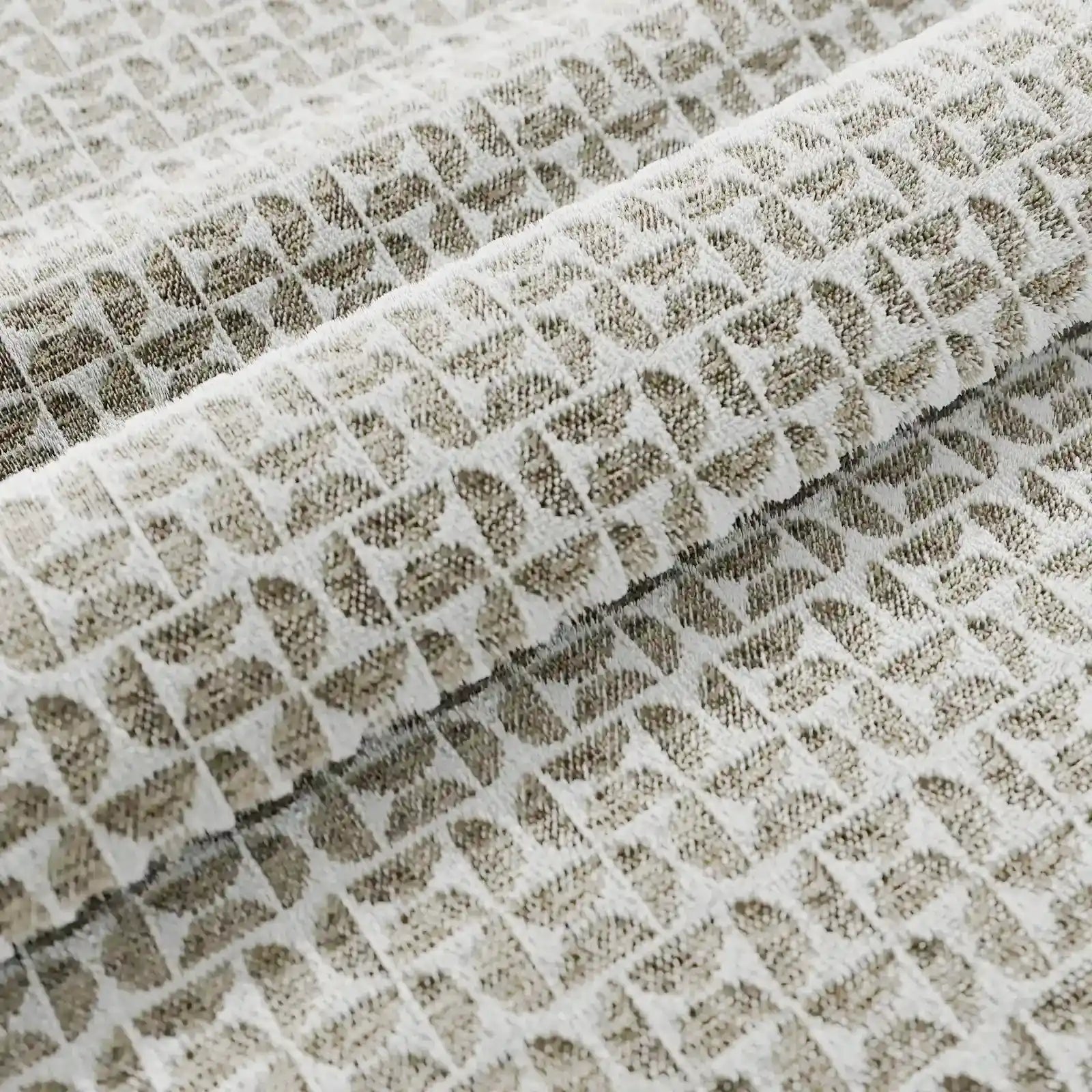 Un primo piano del cuscino decorativo Naxos 45x45 in lino di Divani.Store mostra il tessuto di lino beige pieghettato con motivi a rombi in rilievo di colore grigio chiaro, che conferiscono a questo cuscino decorativo una raffinata trama geometrica e un design elegante.