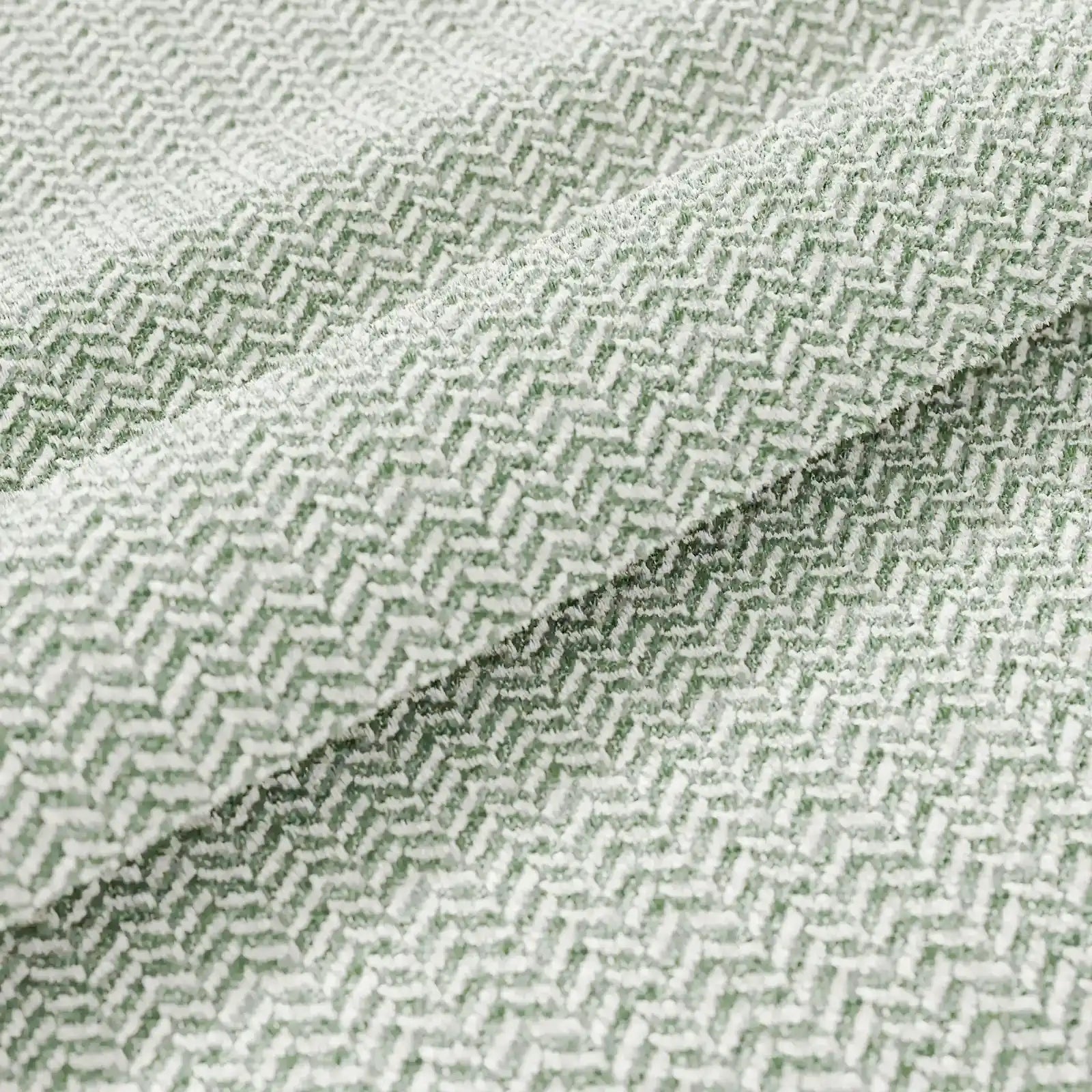 Un primo piano del cuscino Sorrento 45x45 in lino di Divani.Store rivela un motivo a spina di pesce intrecciato nei toni del verde chiaro e del bianco, che conferisce a questo morbido cuscino in lino una sottile eleganza geometrica e una texture delicata, rendendolo ideale per interni raffinati.