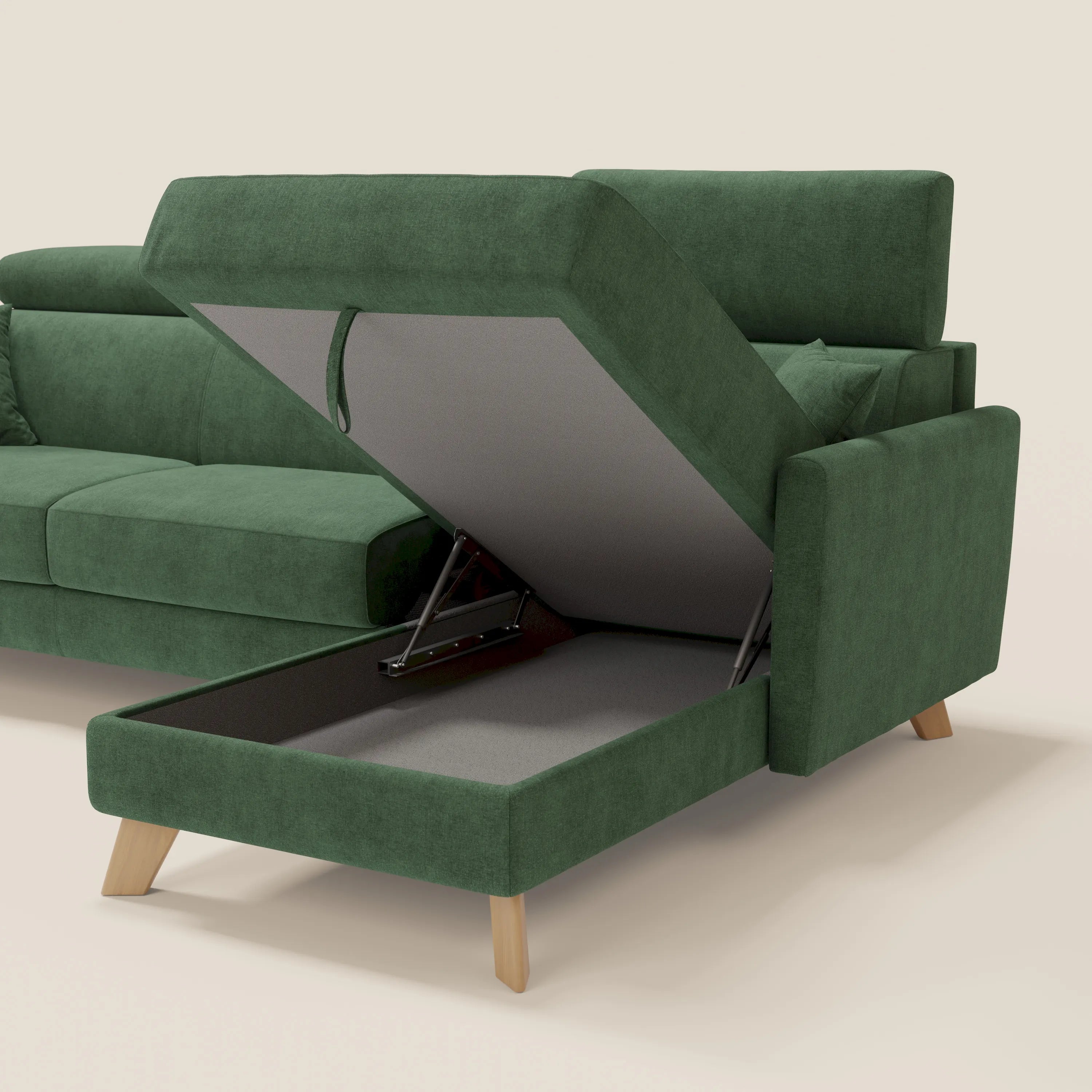 Il divano letto angolare sfoderabile Francy di Divani.Store in smacchiabile T17 verde è caratterizzato da una penisola contenitore nascosta, poggiatesta reclinabili e moderne gambe in legno. La seduta rialzata rivela un vano rivestito in grigio con cerniere in metallo su uno sfondo bianco sporco.