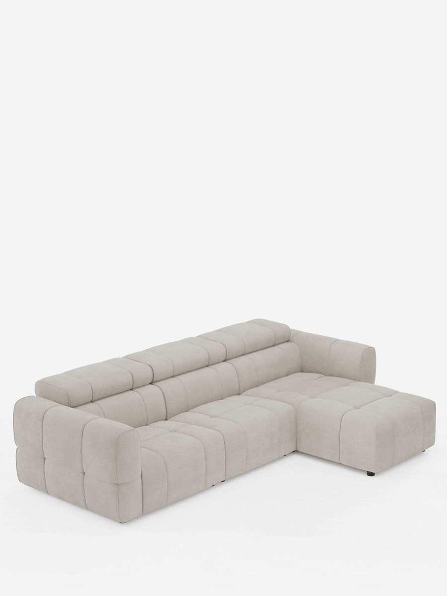 Un divano angolare modulare Giotto beige a 5 posti, lungo 296 cm, con penisola e funzione relax elettrica opzionale, rivestito in tessuto smacchiabile T23 con chaise longue a destra e motivo trapuntato a quadrati su sfondo bianco a tinta unita.