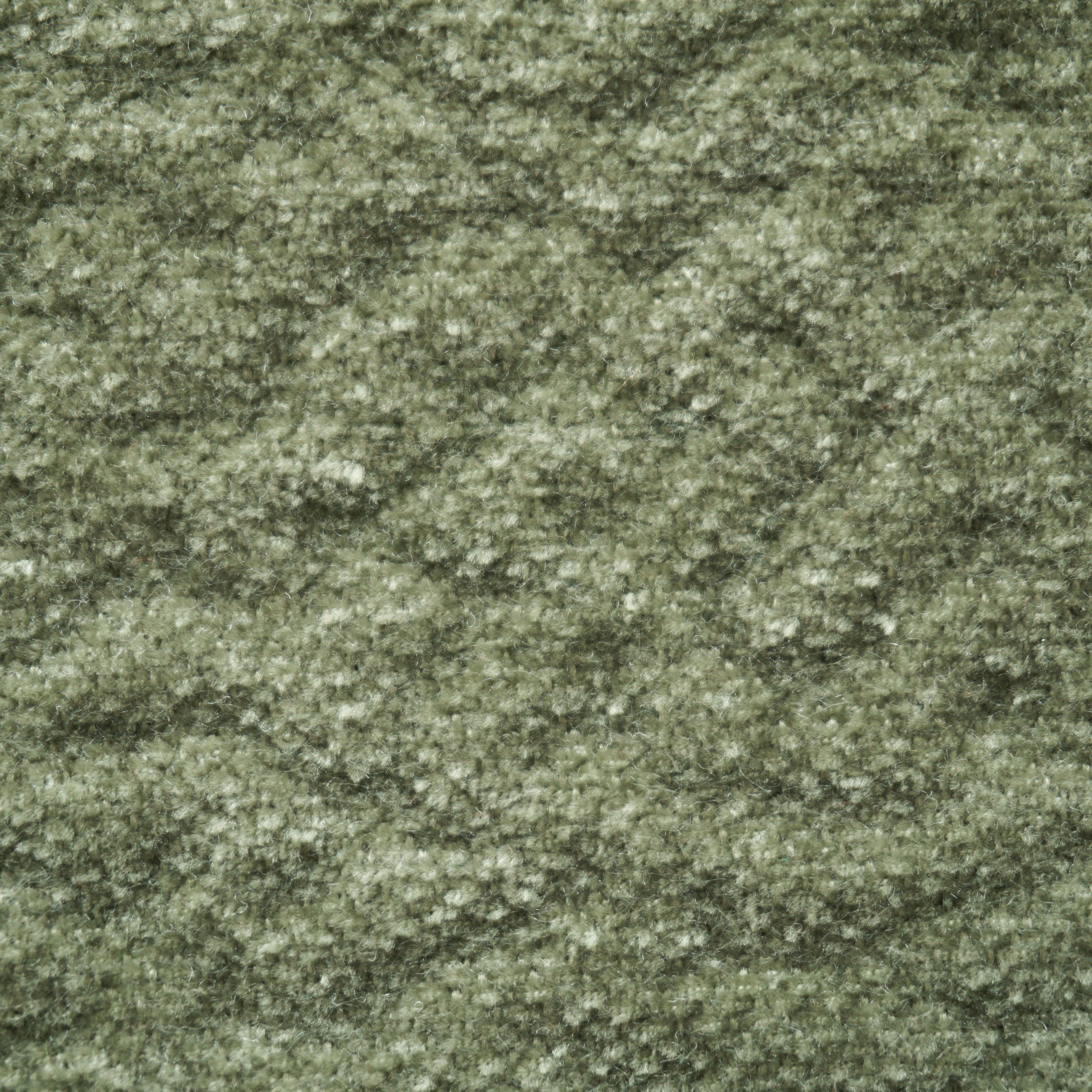 Primo piano del tappeto T27 Brezza di Divani.Store: una superficie verde, soffice e ondulata, in morbida ciniglia, caratterizzata da fibre corte e fitte e da un'elegante lucentezza. Prodotto in Italia con trattamento antimacchia per una bellezza duratura.