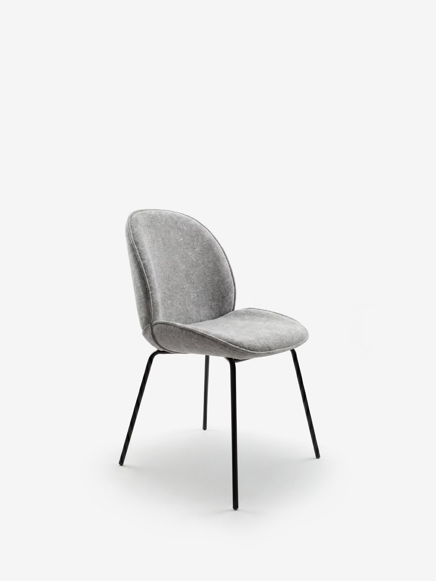 La sedia imbottita Iride di Divani.Store presenta una seduta e uno schienale in tessuto dalla trama morbida di colore grigio, dal design sinuoso, e gambe minimaliste in metallo nero, messe in risalto su uno sfondo bianco per un look moderno e contemporaneo.