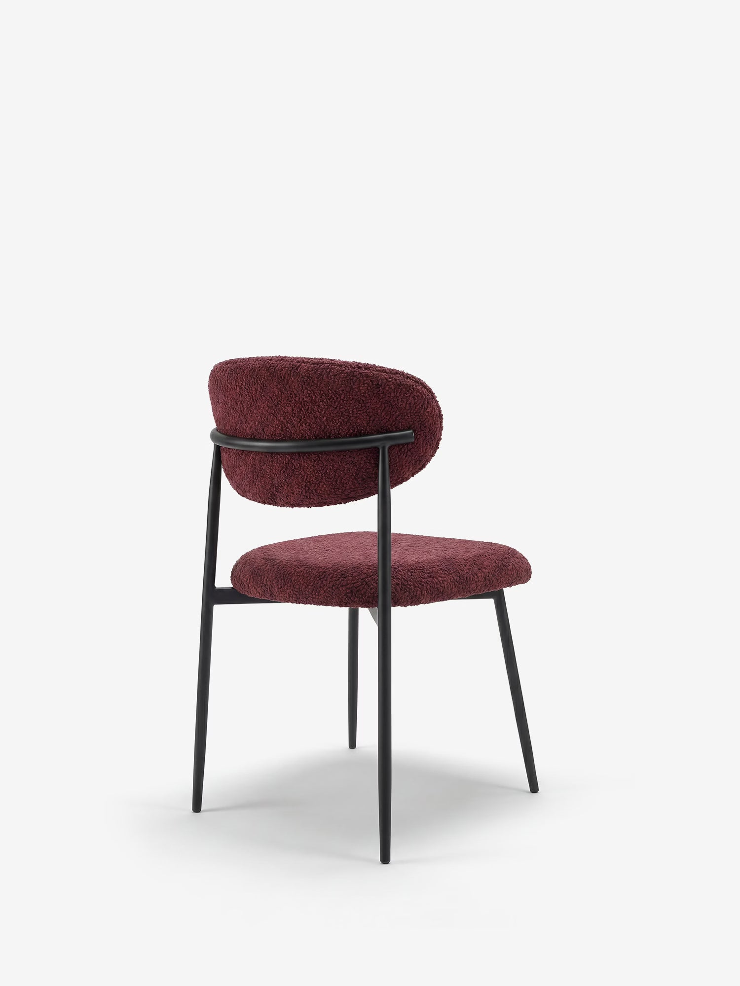 La sedia imbottita Luce in morbida ciniglia di Divani.Store presenta uno schienale arrotondato e una seduta imbottita in tessuto bordeaux testurizzato, sostenuta da eleganti gambe in metallo nero che le conferiscono un look minimalista e contemporaneo.