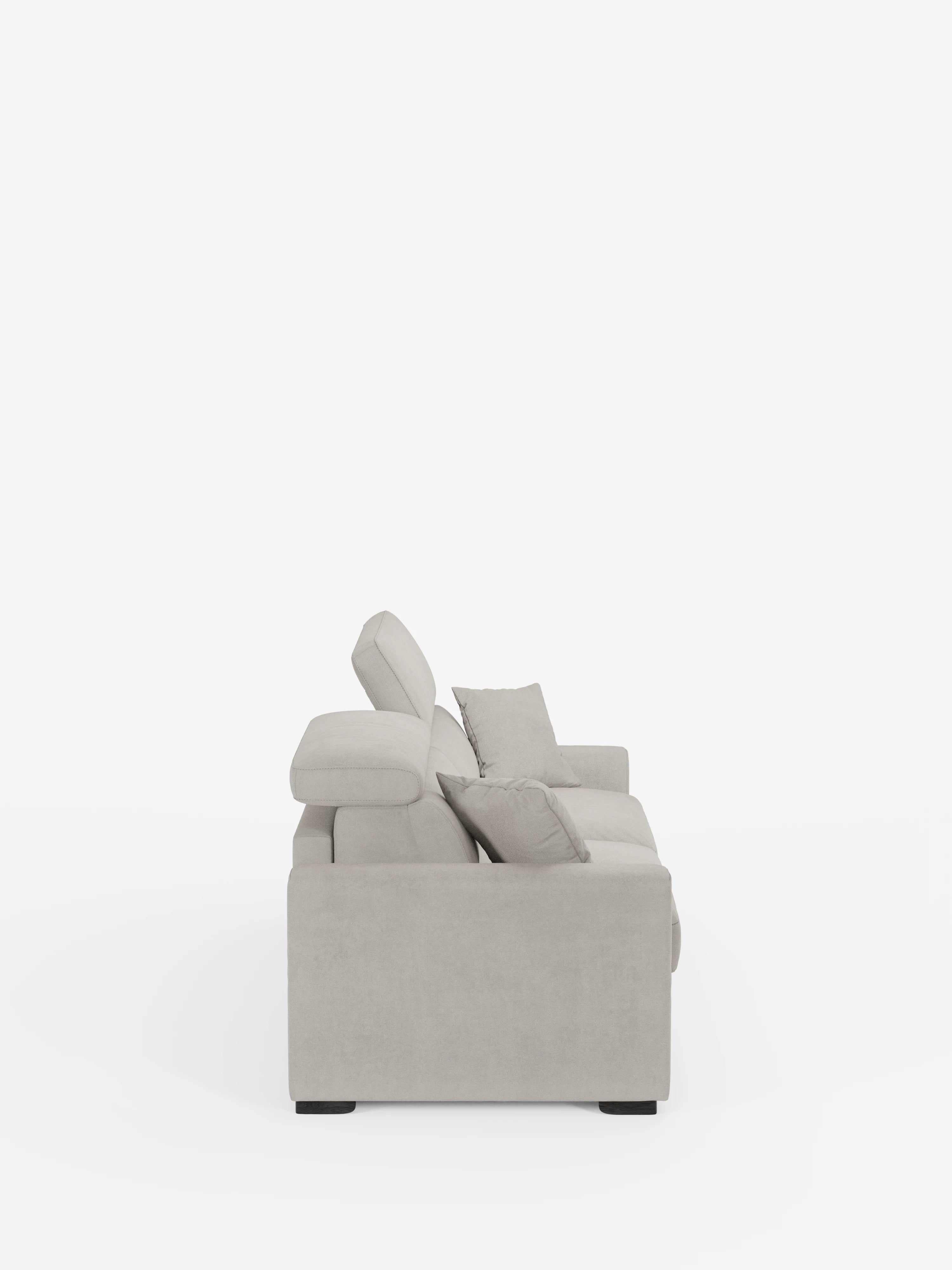 Vista laterale del divano letto Maximus a 3 posti con materasso ALTO 20 cm di Divani.Store, rivestito in tessuto grigio chiaro, resistente alle macchie e certificato Oeko-Tex. Il divano presenta eleganti gambe nere, due cuscini di seduta e due cuscini dello schienale. Due cuscini decorativi sono disposti lungo il bracciolo e lo schienale. I poggiatesta reclinabili sono leggermente sollevati per mettere in risalto il loro design moderno. Lo sfondo è bianco a tinta unita.