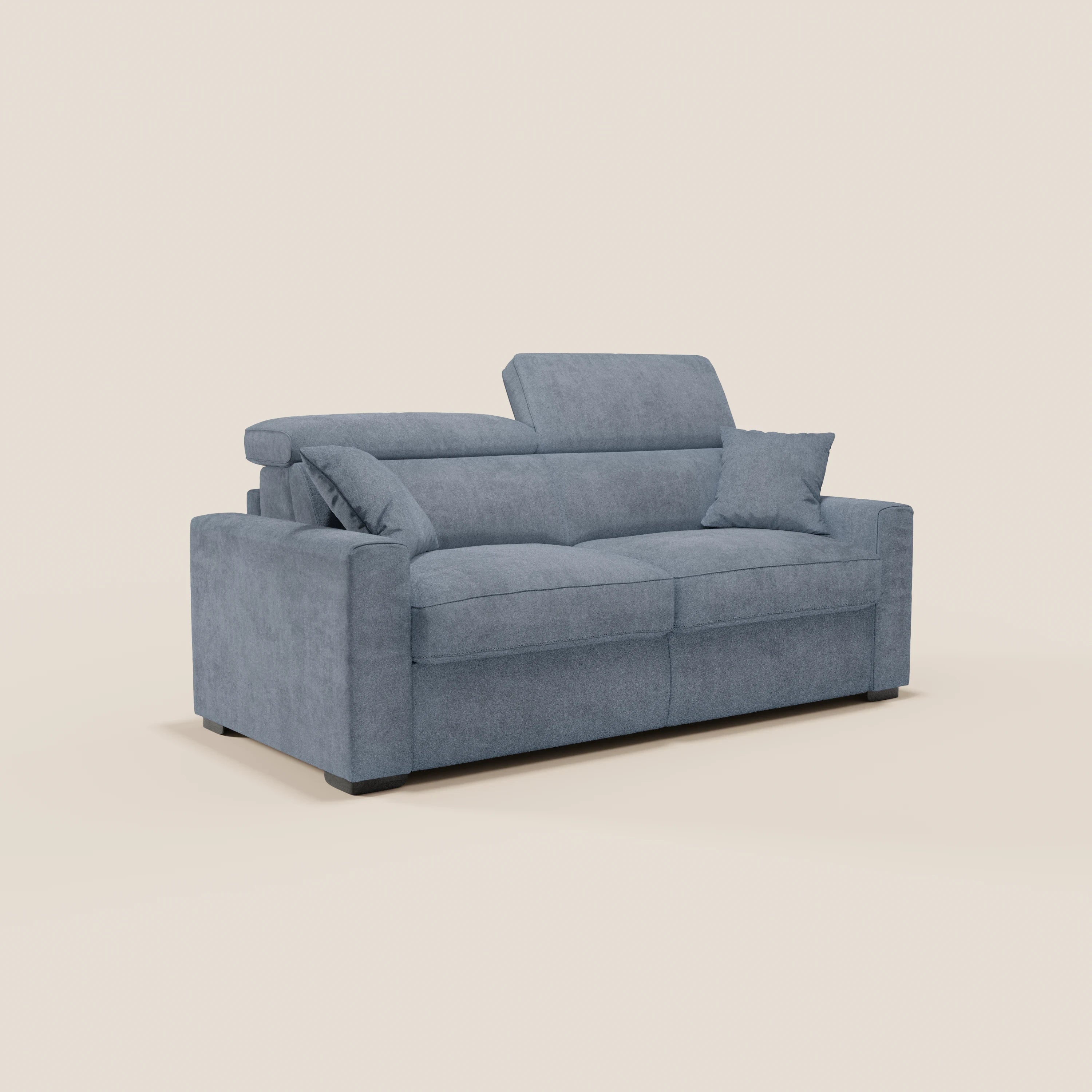 Un divano letto a 3 posti Maximus in stile contemporaneo di Divani.Modello rivestito in tessuto Oeko-Tex resistente alle macchie di colore azzurro chiaro, dotato di due cuscini di seduta, poggiatesta reclinabili, ampi braccioli, un materasso alto 20 cm e un cuscino decorativo abbinato, presentato su uno sfondo bianco sporco.