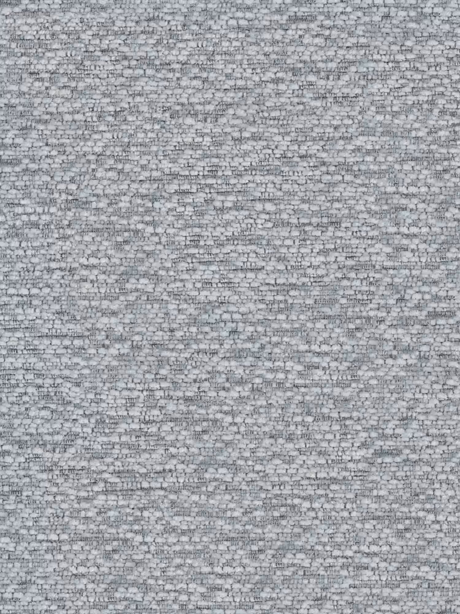 Un primo piano di una parete in mattoni grigi, composta da piccoli mattoni rettangolari, fa da sfondo ricco di texture alla sedia Iride, imbottita in morbido tessuto materico con struttura in metallo nero di Divani.Store, conferendo un tocco di stile moderno a qualsiasi soggiorno.